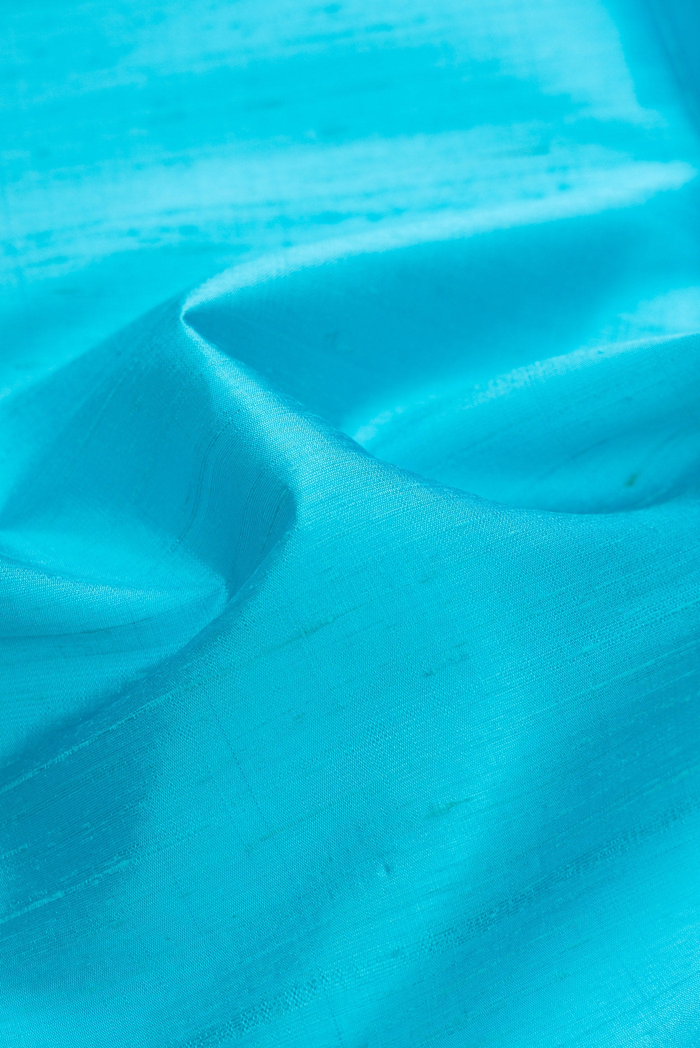 Close up of Sky Blue Dual Tone Raw Silk Saree with Plain Body and Zari Border.  displaying folds