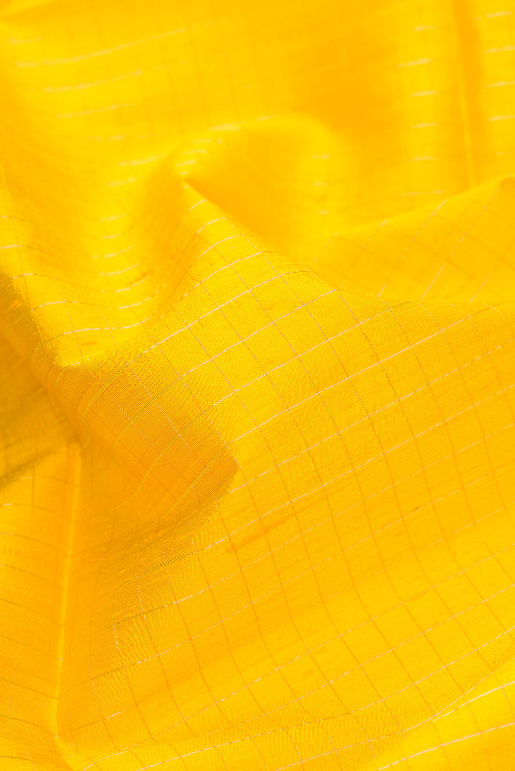 Close up of Yellow Dual Tone Raw Silk Saree with Checked design on the body and Thin Zari Line.  displaying folds