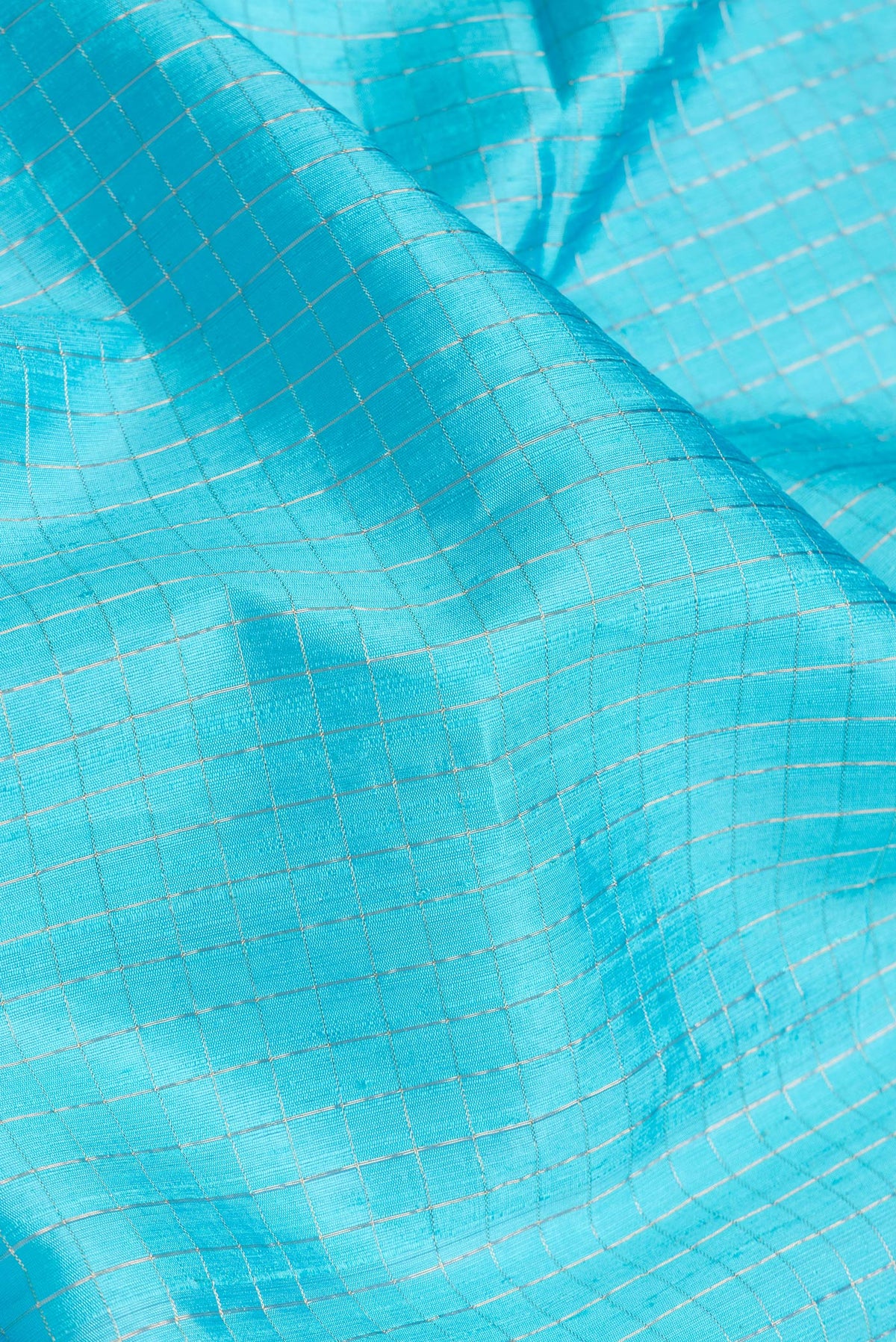 Close up of Sky Blue Dual Tone Raw Silk Saree with Checked design on the body and Zari Border.  displaying folds