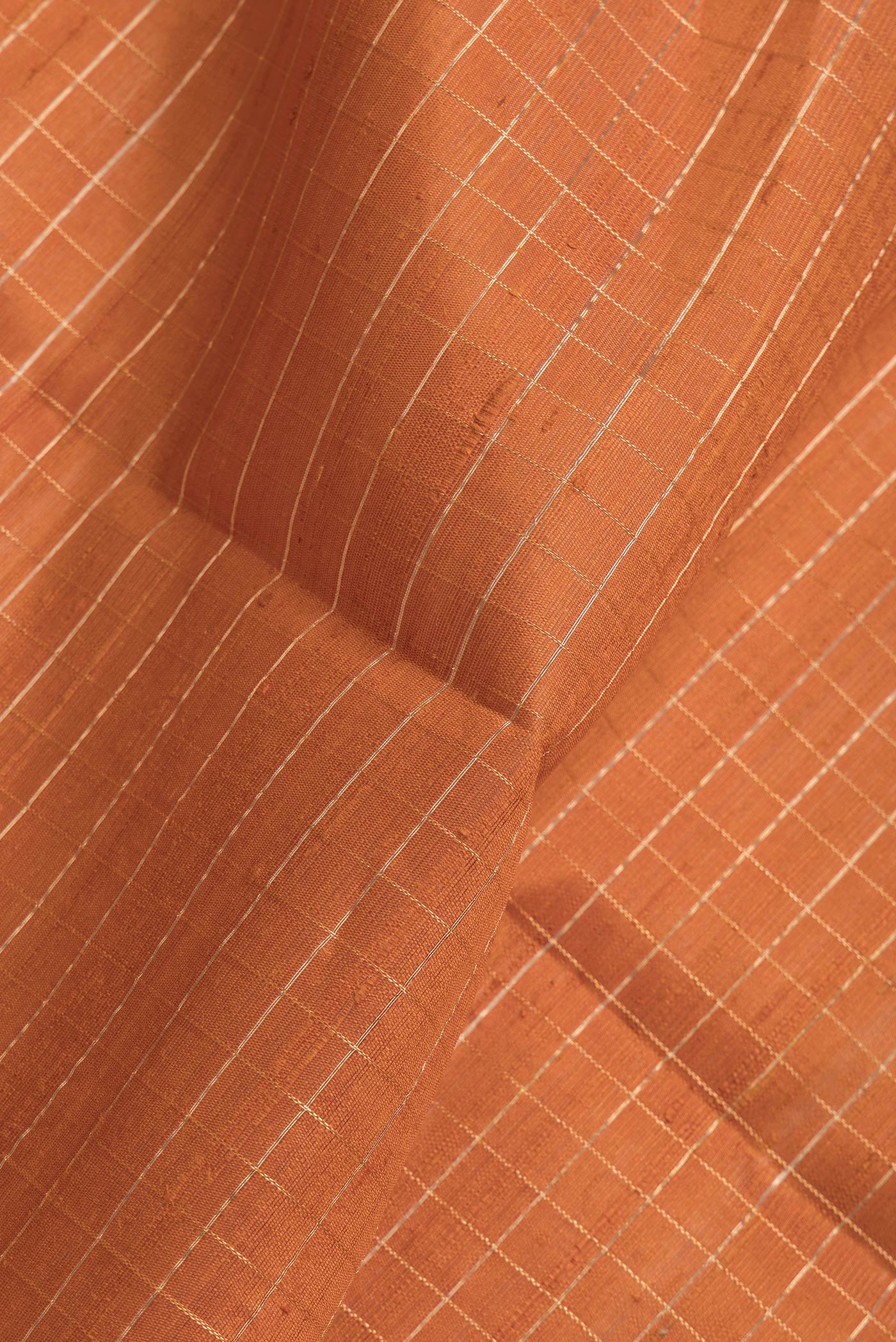 Close up of Bronze Dual Tone Raw Silk Saree with Checked design on the body and Thin Zari Line.  displaying folds