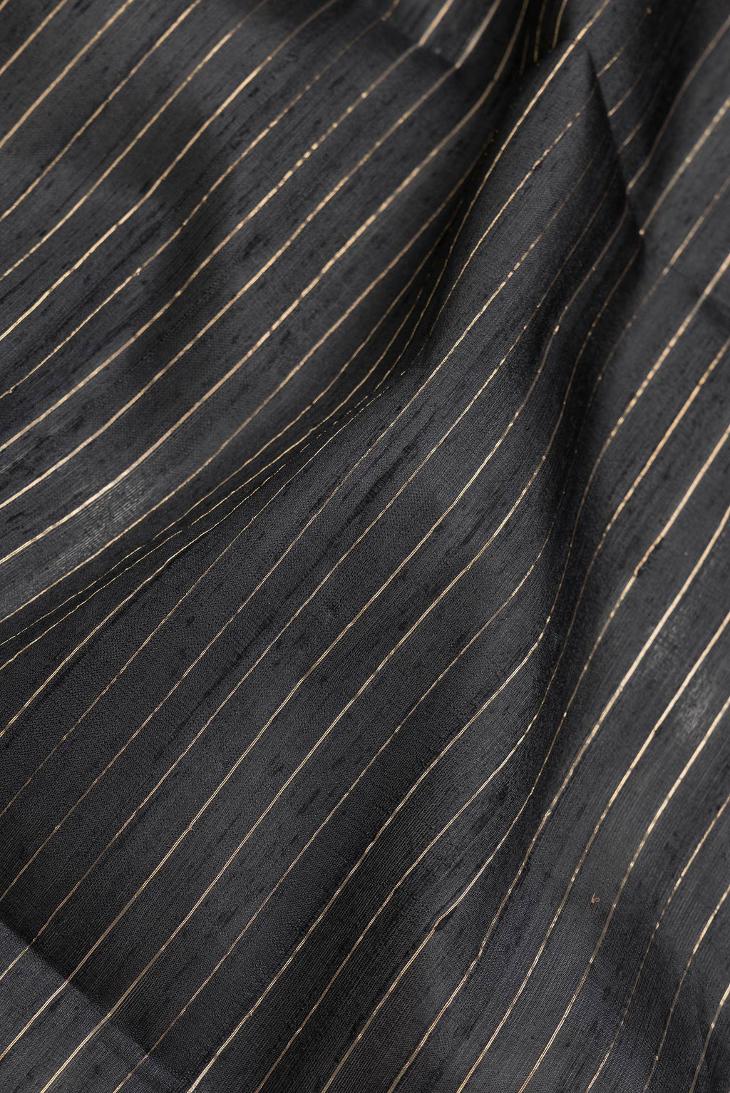 Close up of Black Dual Tone Raw Silk Saree with Checked design on the body and Temple Border.  displaying folds