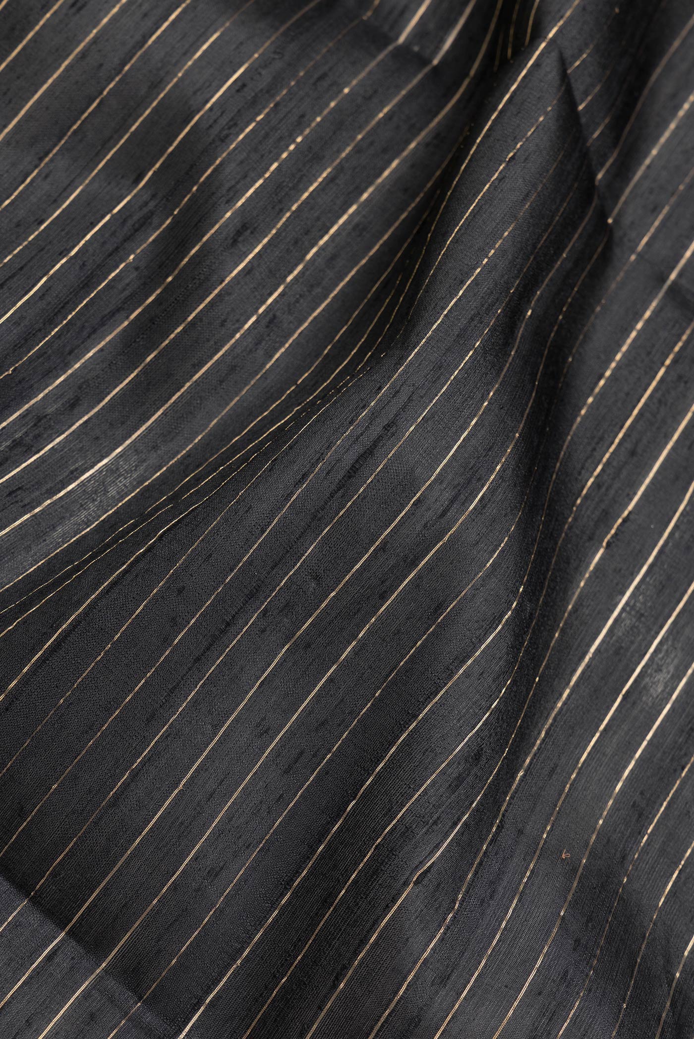 Close up of Black Dual Tone Raw Silk Saree with Checked design on the body and Temple Border.  displaying folds