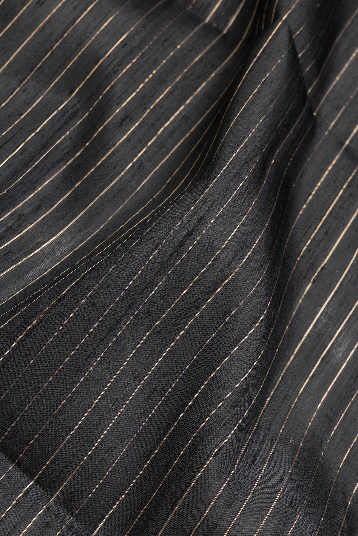 Close up of Black Dual Tone Raw Silk Saree with Checked design on the body and Temple Border.  displaying folds
