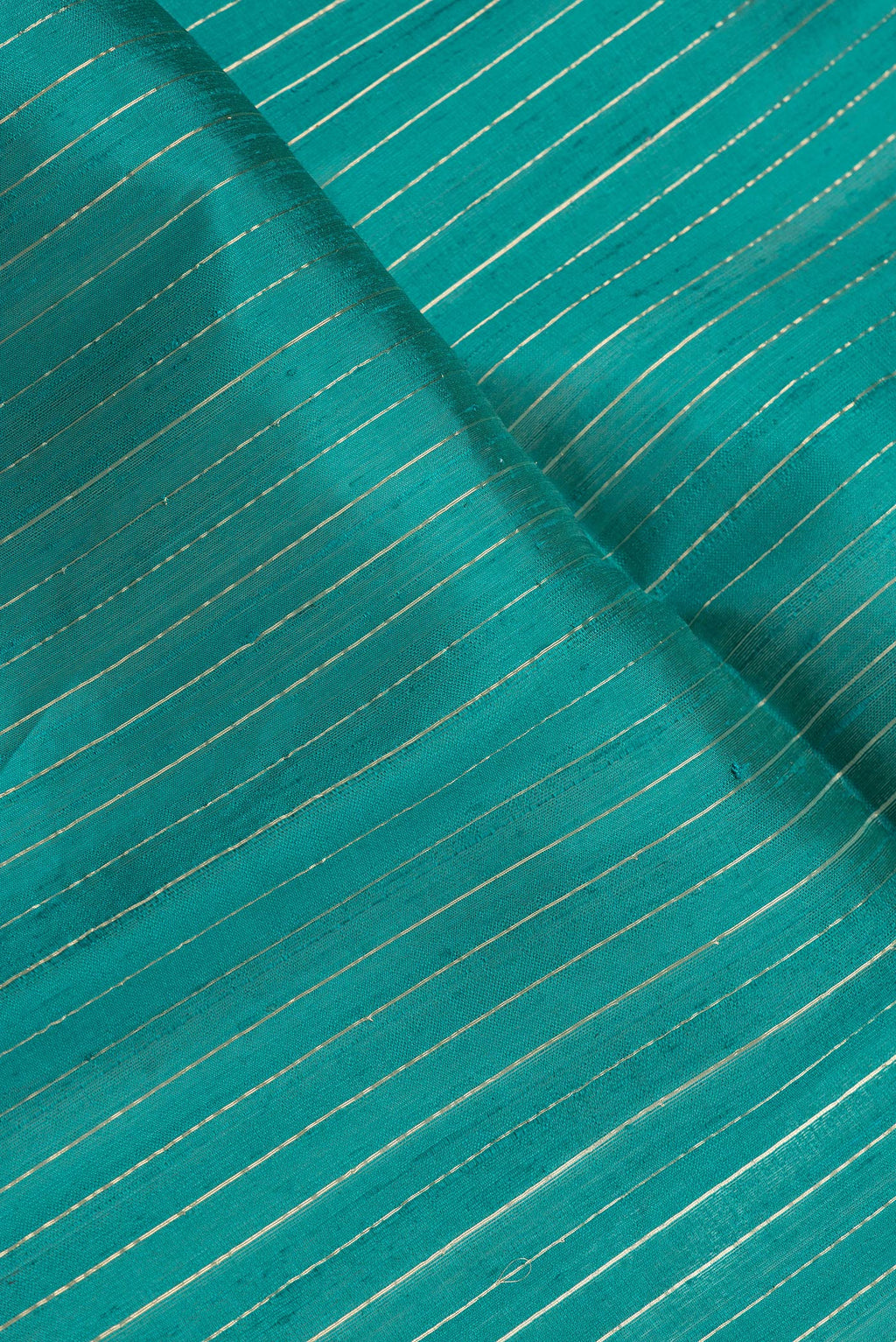 Close up of Peacock Blue Dual Tone Raw Silk Saree with Stripes on the body and Temple Border.  displaying folds
