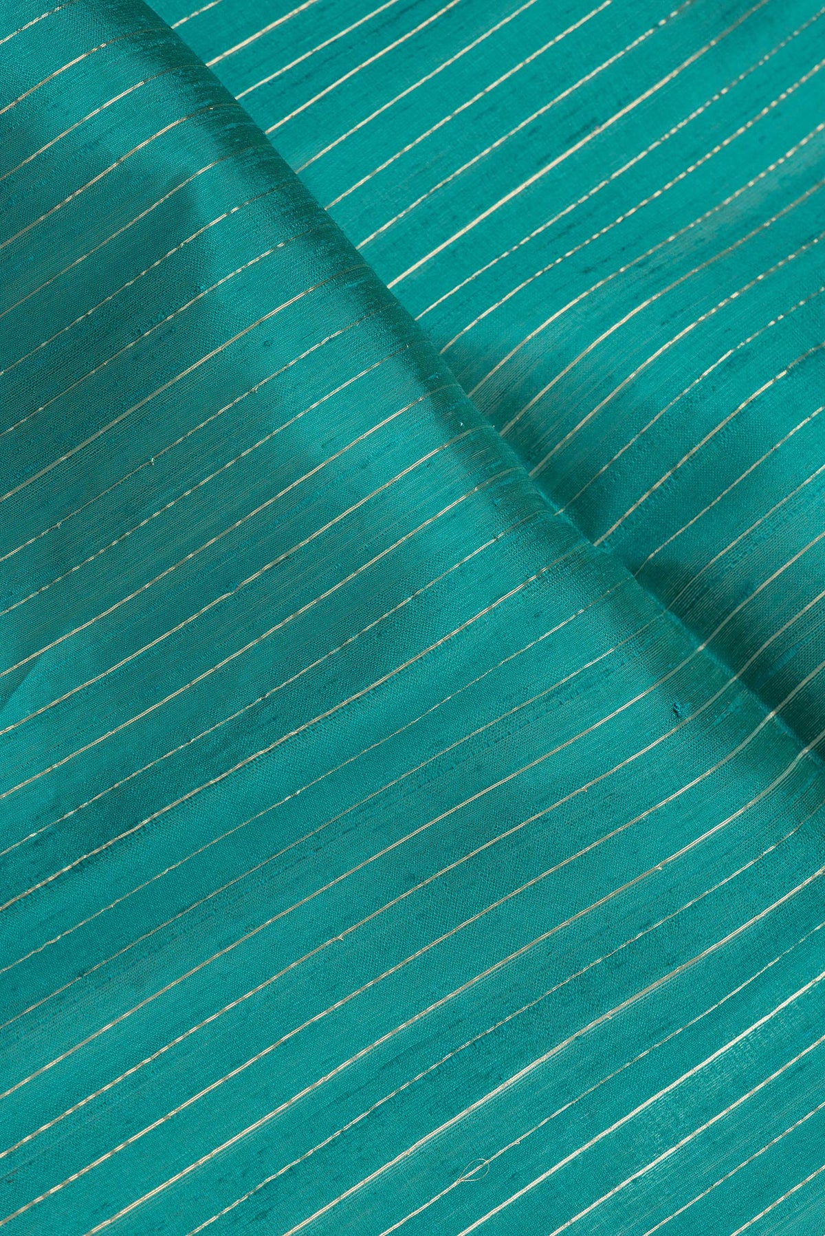 Close up of Peacock Blue Dual Tone Raw Silk Saree with Stripes on the body and Temple Border.  displaying folds