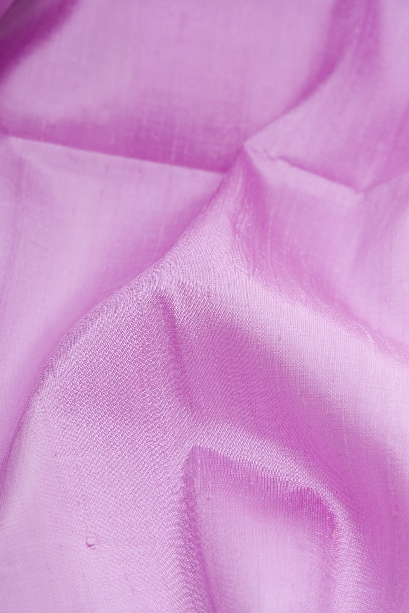 Close up of Lavender Dual Tone Raw Silk Saree with Zari Butta on the body and Zari Border.  displaying folds