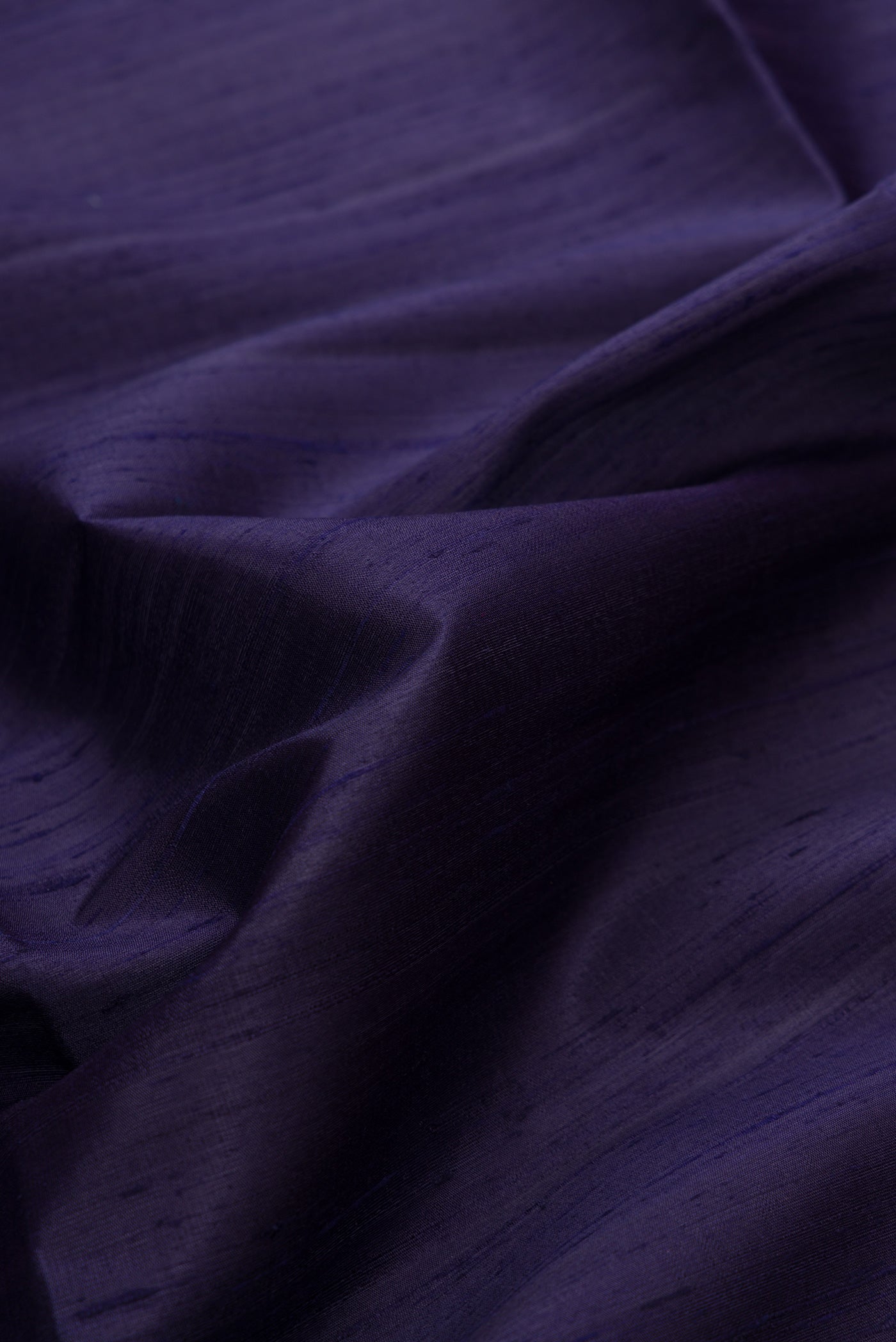 Close up of Navy Blue Dual Tone Raw Silk Saree with Plain Body and Thin Zari Line.  displaying folds