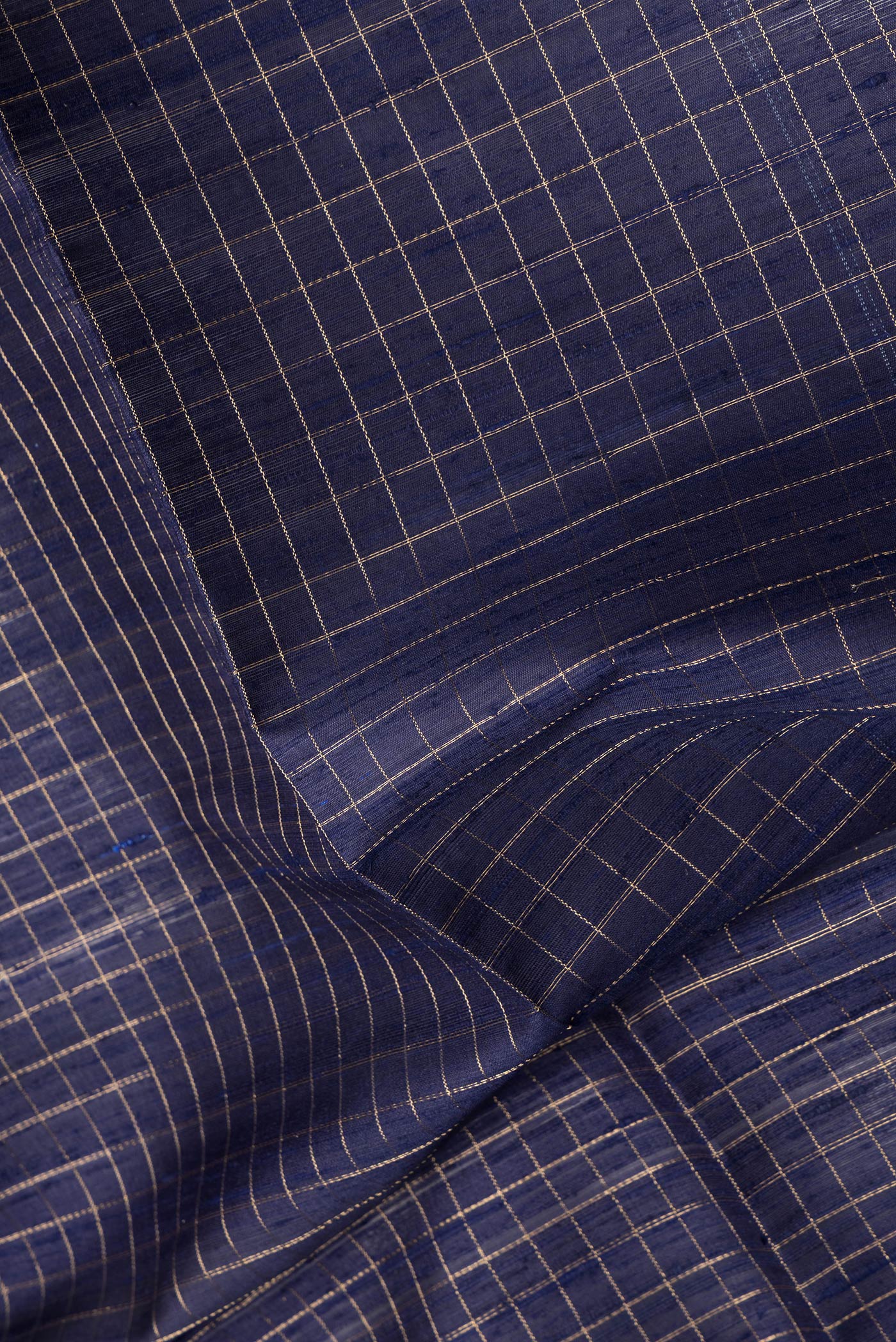 Close up of Navy Blue Dual Tone Raw Silk Saree with Checked design on the body and Zari Border.  displaying folds