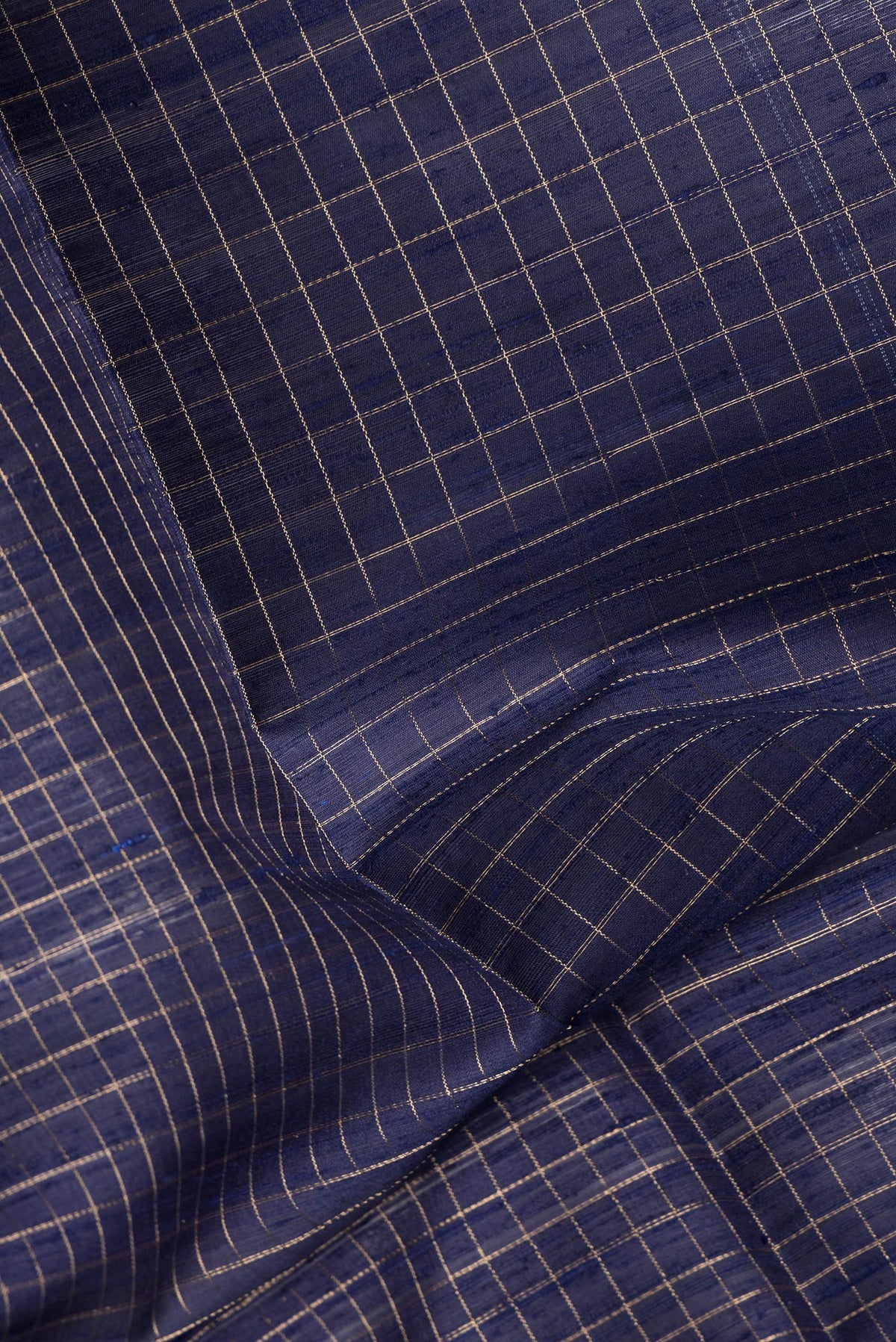 Close up of Navy Blue Dual Tone Raw Silk Saree with Checked design on the body and Zari Border.  displaying folds