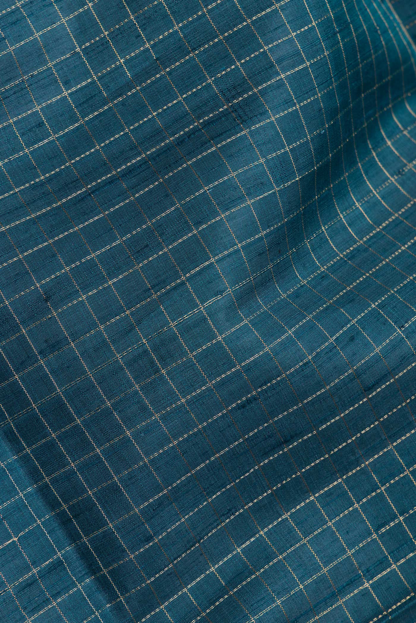 Close up of Peacock Blue Dual Tone Raw Silk Saree with Checked design on the body and Zari Border.  displaying folds