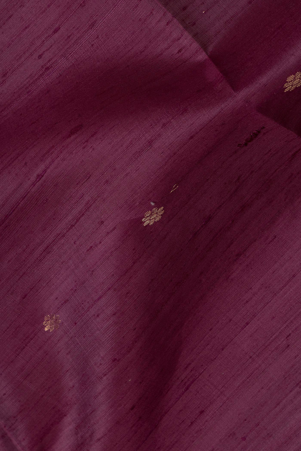 Close up of Purple Dual Tone Raw Silk Saree with Zari Butta on the body and Plain Border.  displaying folds
