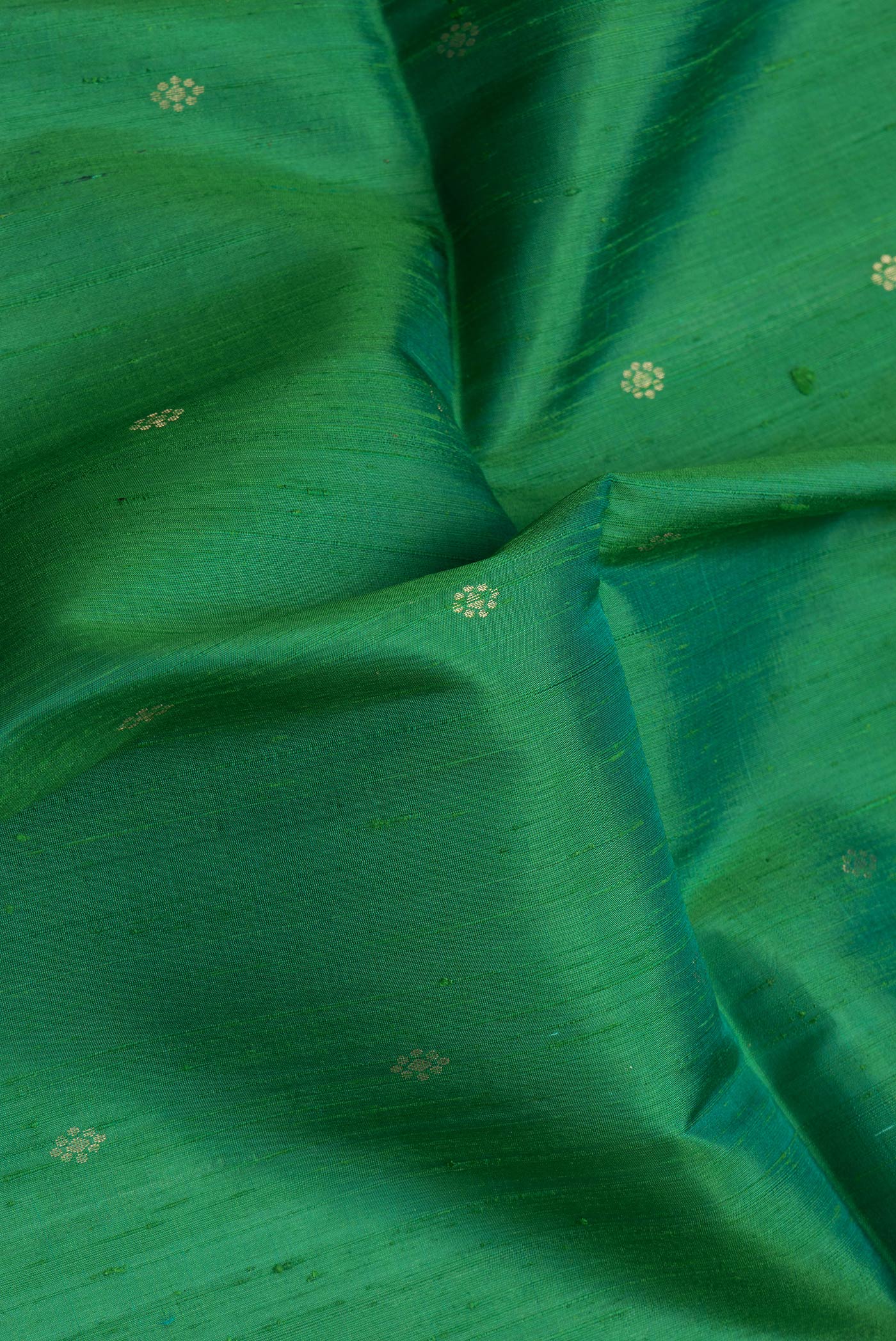 Close up of Bottle Green Dual Tone Raw Silk Saree with Zari Butta on the body and Thin Zari Line.  displaying folds