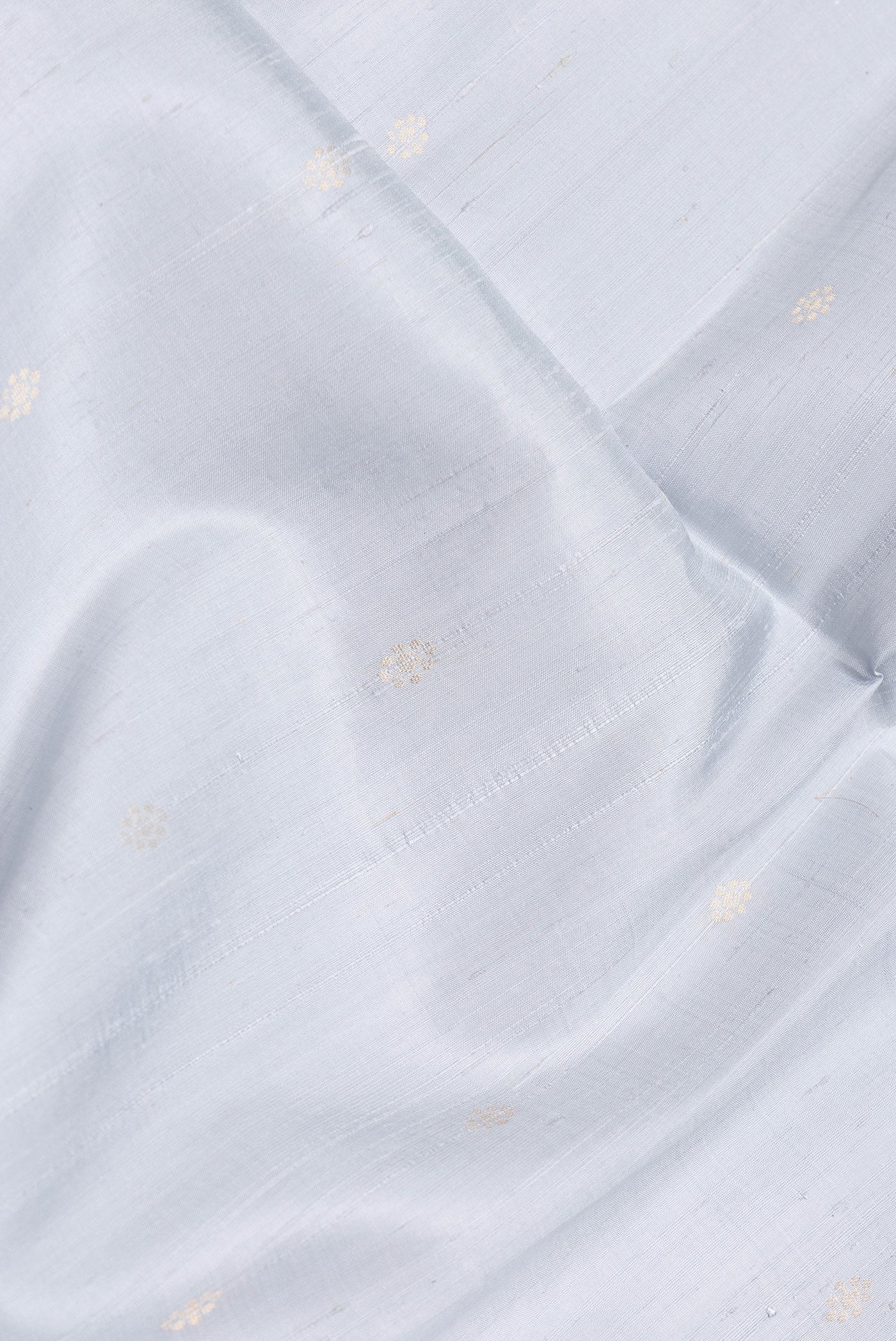 Close up of Grey Dual Tone Raw Silk Saree with Zari Butta on the body and Zari Border.  displaying folds