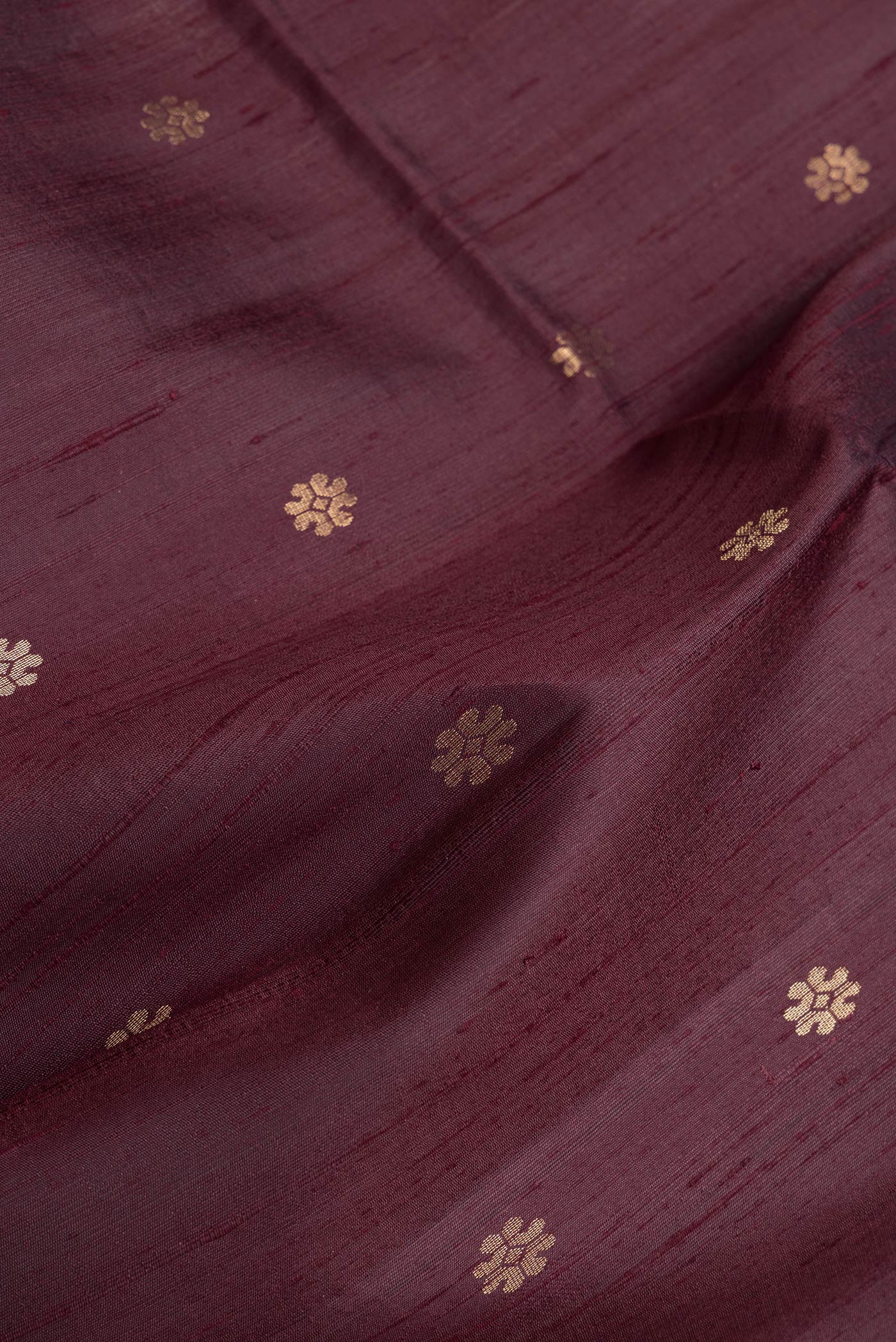 Close up of Brown Dual Tone Raw Silk Saree with Zari Butta on the body and Zari Border.  displaying folds