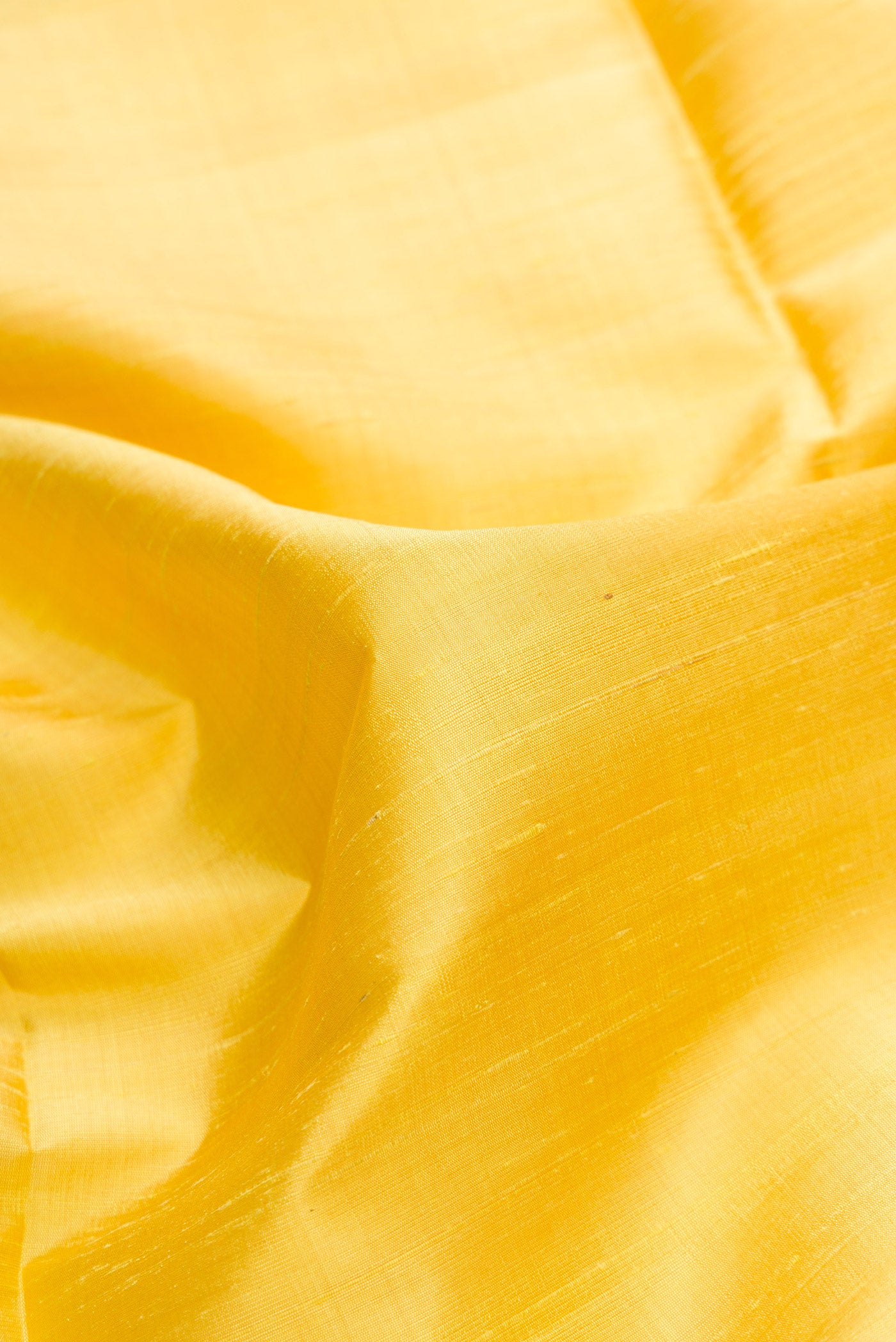 Close up of Lemon Yellow Dual Tone Raw Silk Saree with Plain Body and Fancy Border.  displaying folds