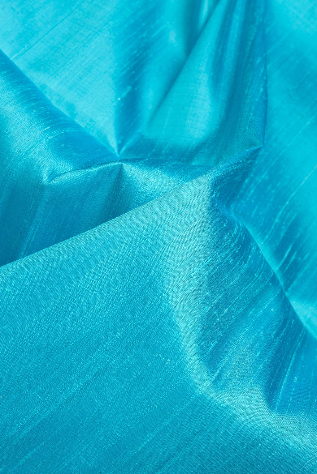 Close up of Sky Blue Dual Tone Raw Silk Saree with Plain Body and Fancy Border.  displaying folds