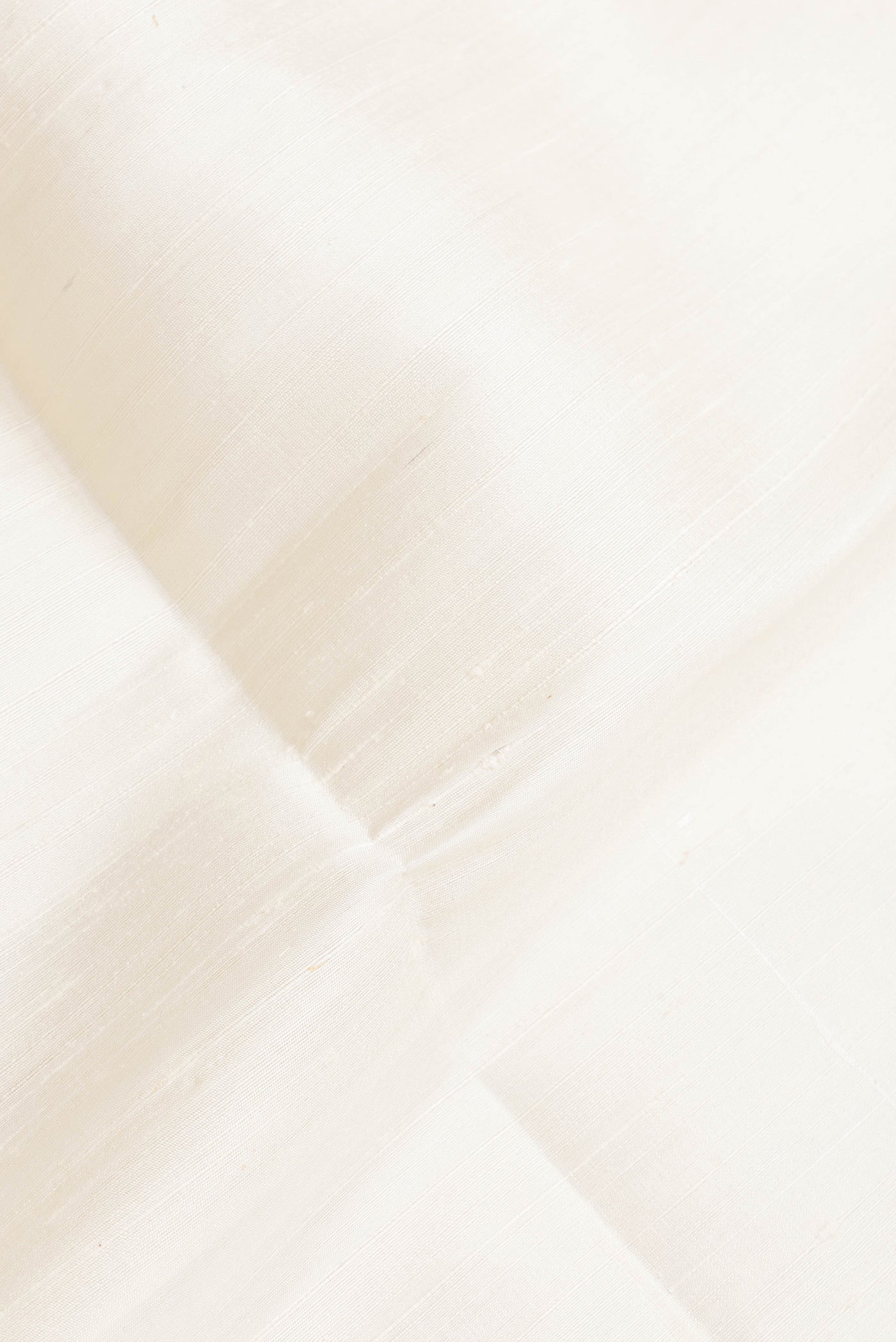 Close up of Off White Dual Tone Raw Silk Saree with Plain Body and Fancy Border.  displaying folds