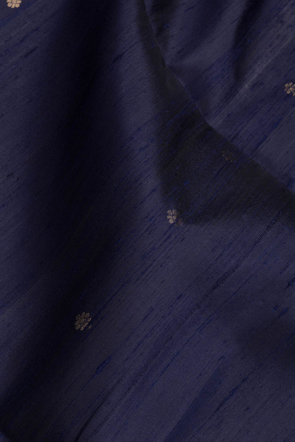Close up of Navy Blue Dual Tone Raw Silk Saree with Zari Butta on the body and Fancy Border.  displaying folds