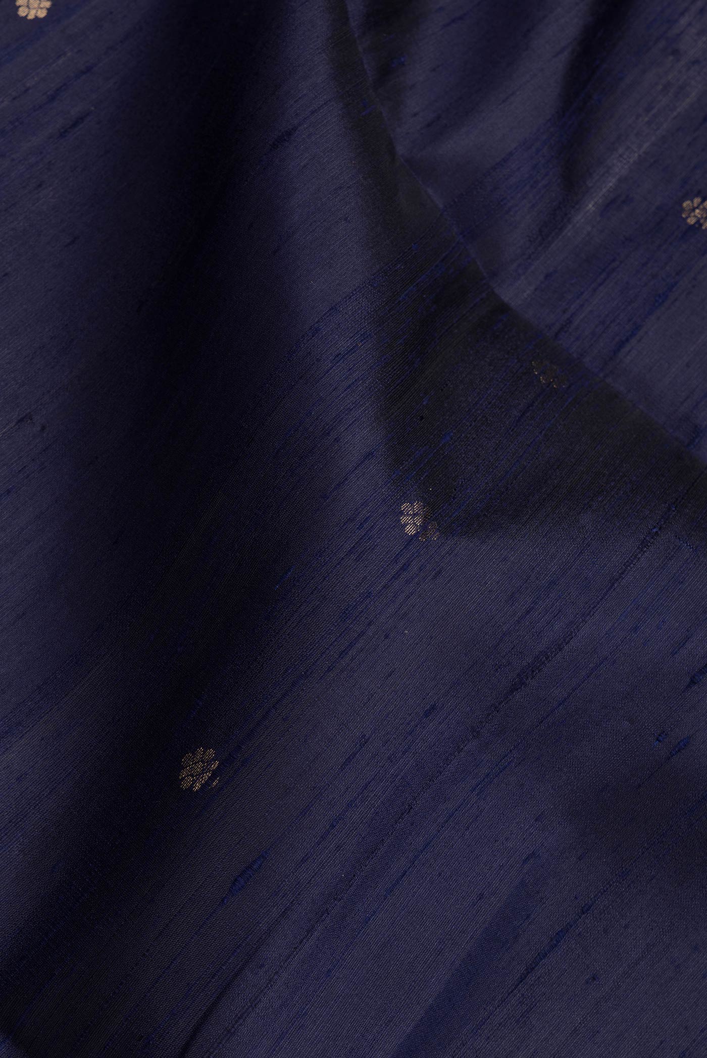 Close up of Navy Blue Dual Tone Raw Silk Saree with Zari Butta on the body and Fancy Border.  displaying folds