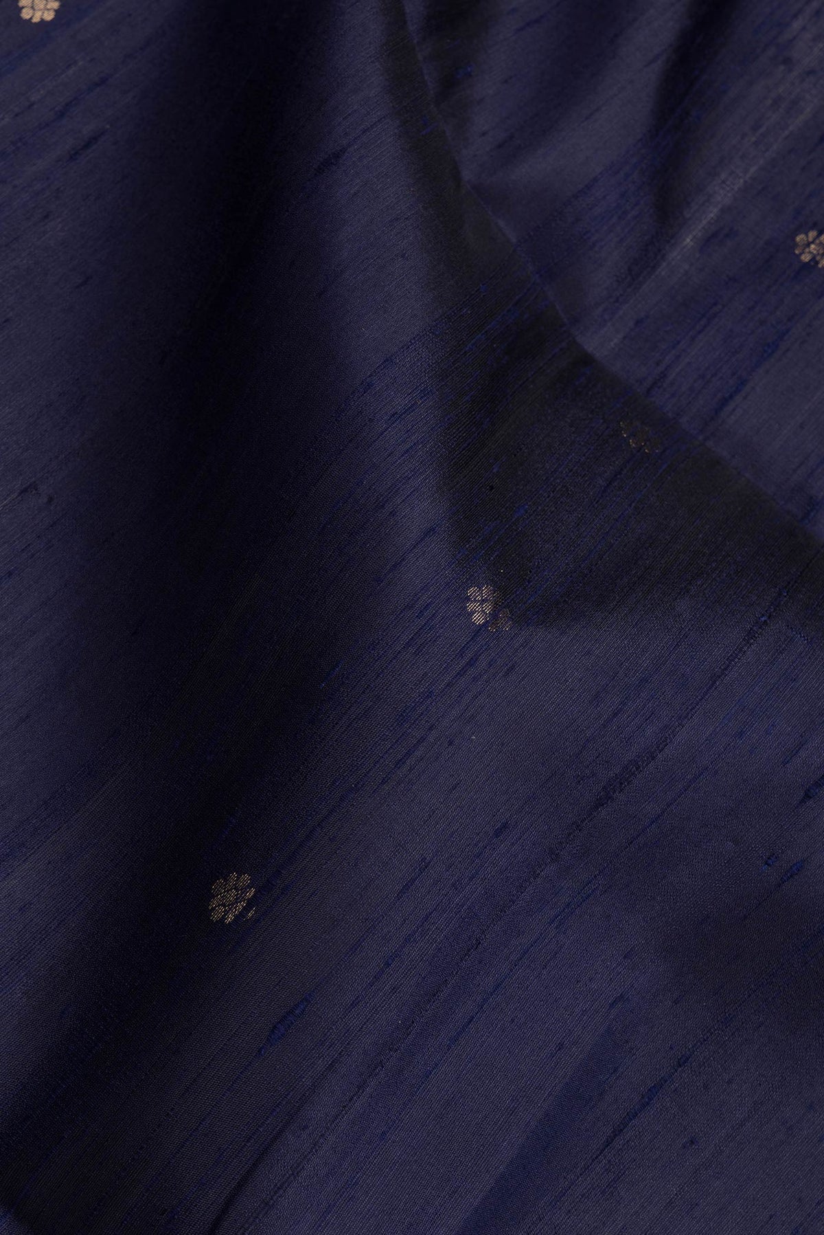 Close up of Navy Blue Dual Tone Raw Silk Saree with Zari Butta on the body and Fancy Border.  displaying folds