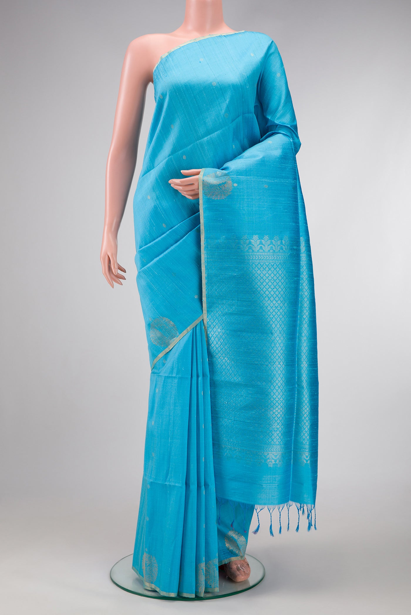 Sky Blue Dual Tone Raw Silk Saree with Zari Butta on the body and Fancy Border.  displayed on a mannequin