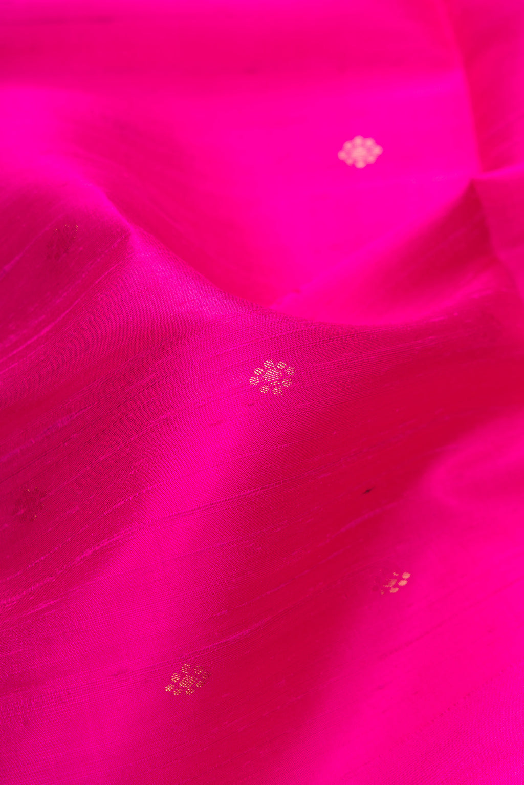 Close up of Magenta Dual Tone Raw Silk Saree with Zari Butta on the body and Zari Border.  displaying folds