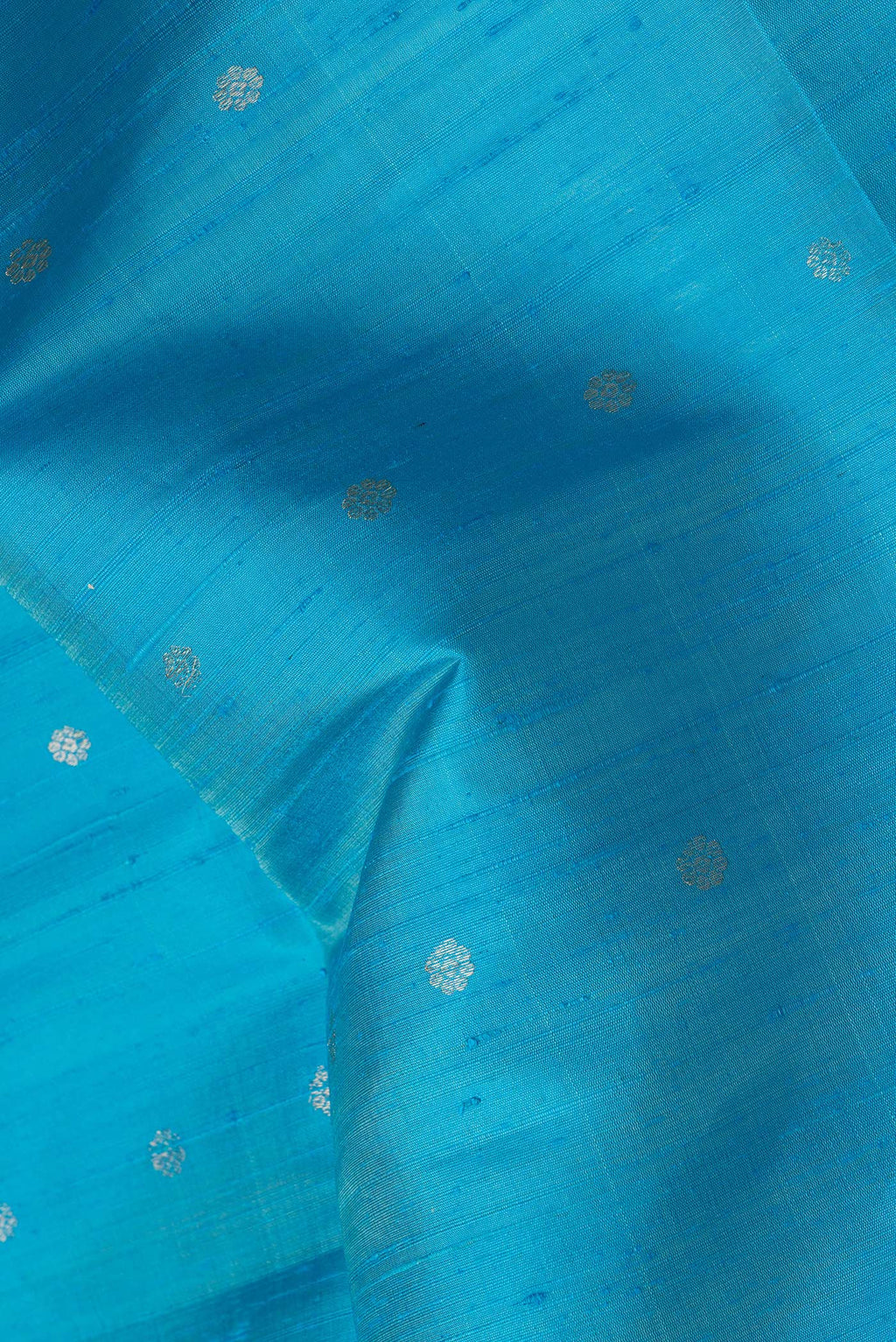 Close up of Sky Blue Dual Tone Raw Silk Saree with Zari Butta on the body and Zari Border.  displaying folds