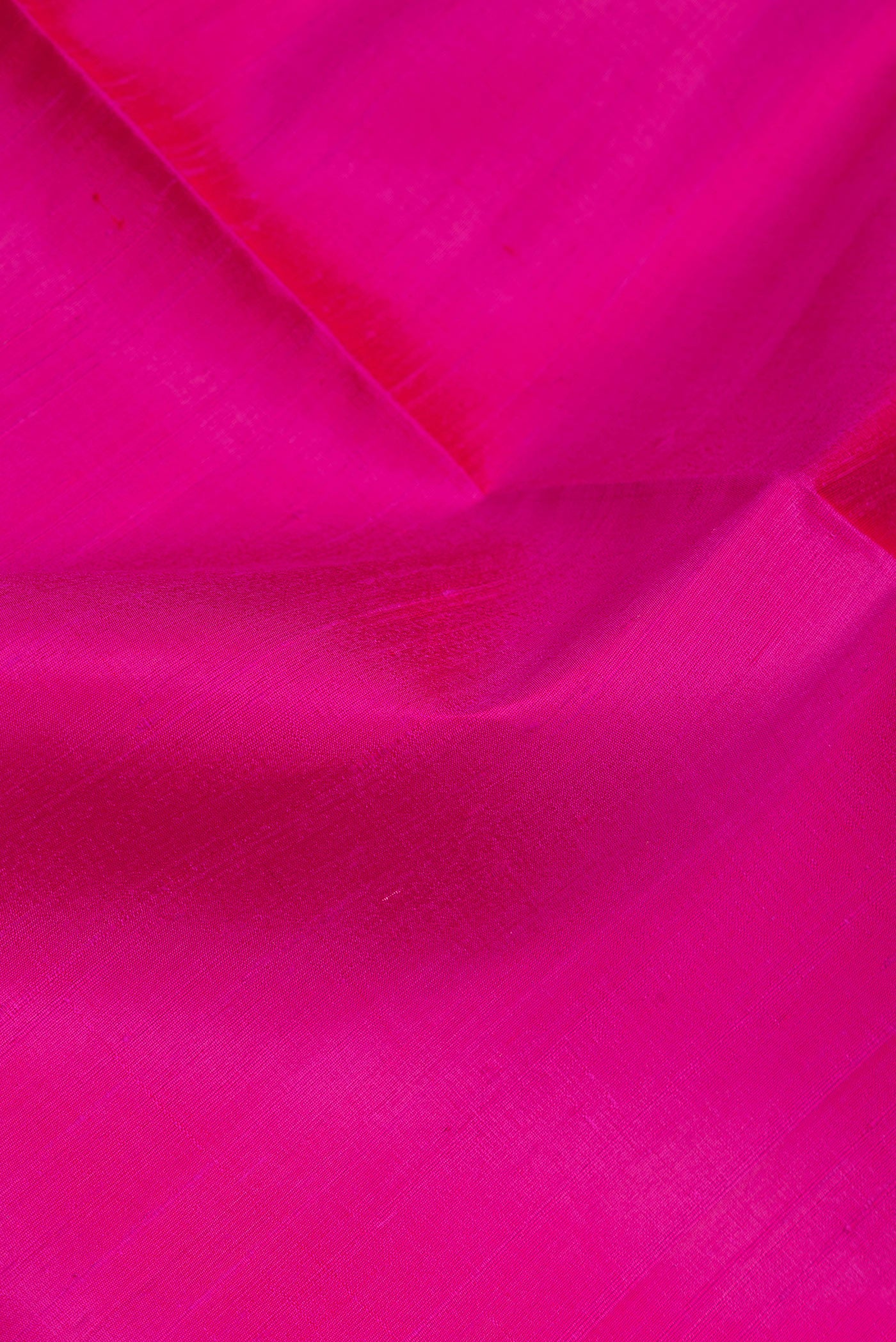 Close up of Dark Pink Dual Tone Raw Silk Saree with Plain Body and Zari Border.  displaying folds