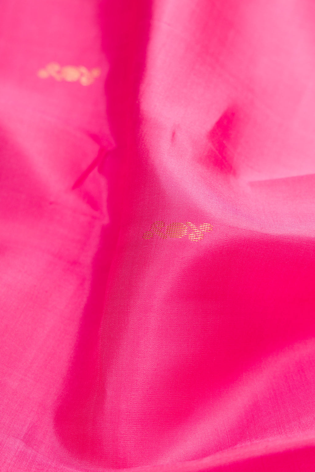 Close up of Pink Kanchipuram Silk Saree with Zari Butta on the body and Zari Border.  displaying folds