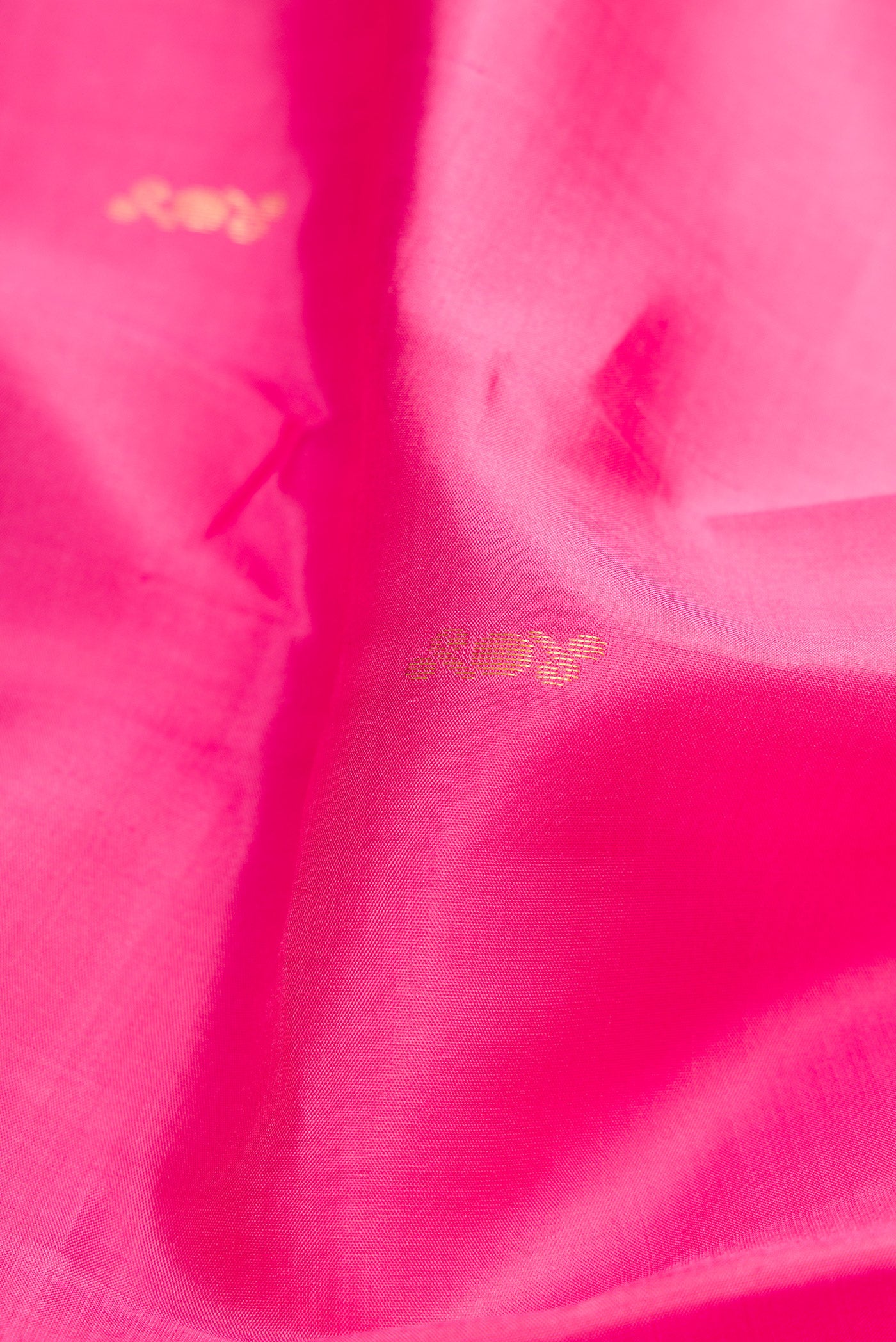 Close up of Pink Kanchipuram Silk Saree with Zari Butta on the body and Zari Border.  displaying folds