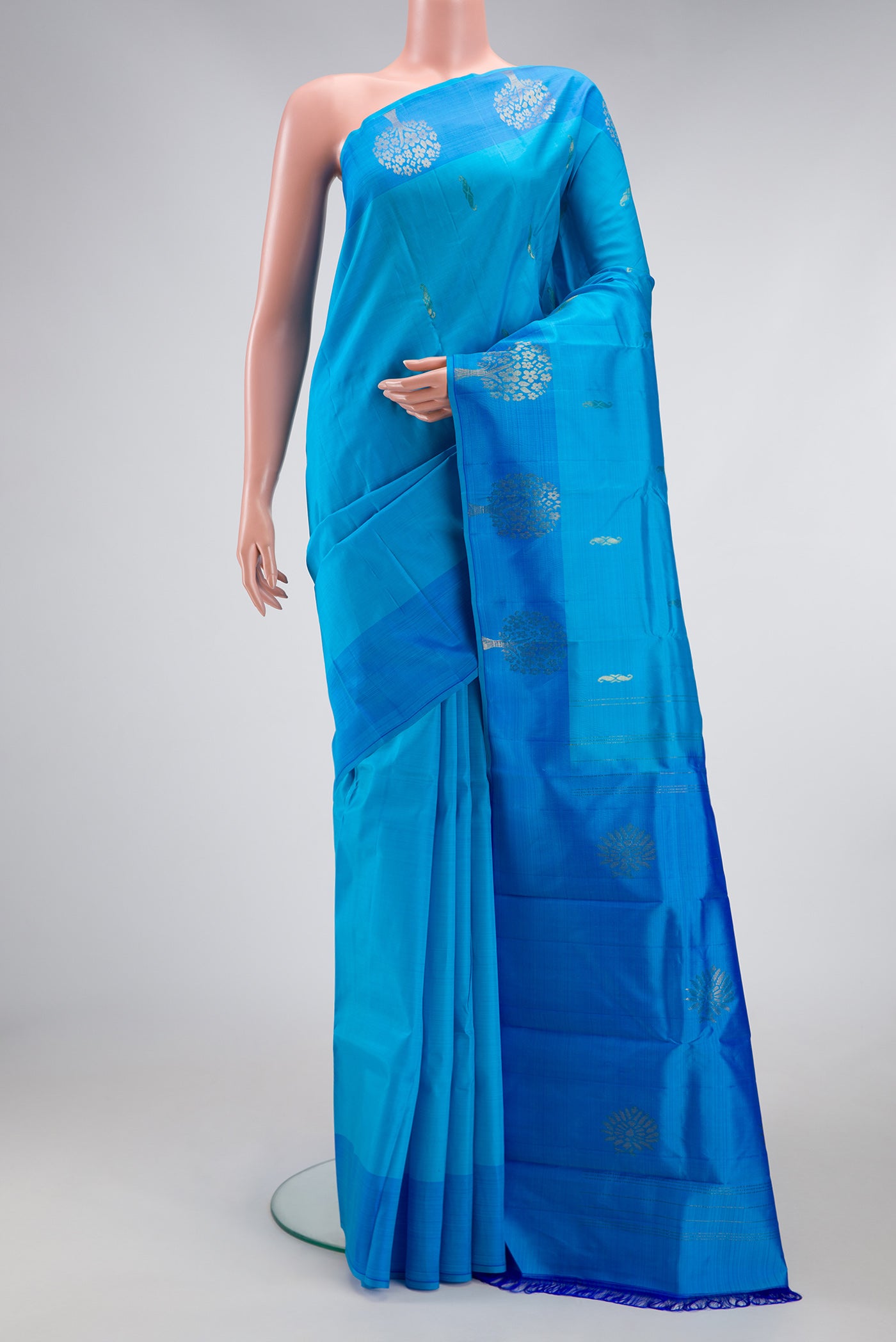 Sky Blue Kanchipuram Silk Saree with Zari Butta on the body and Fancy Border.  displayed on a mannequin
