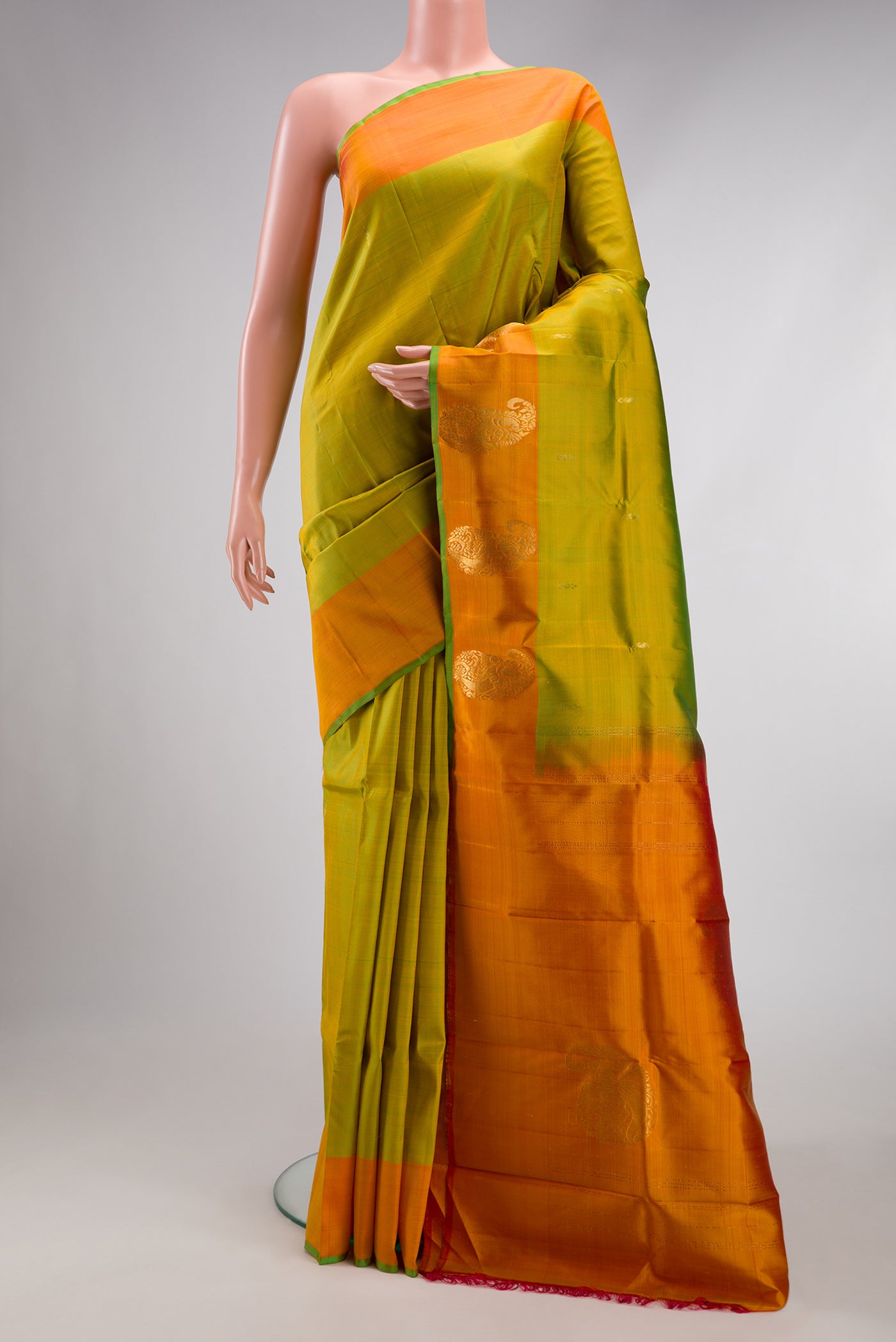 Parrot Green Kanchipuram Silk Saree with Zari Butta on the body and Zari Border.  displayed on a mannequin