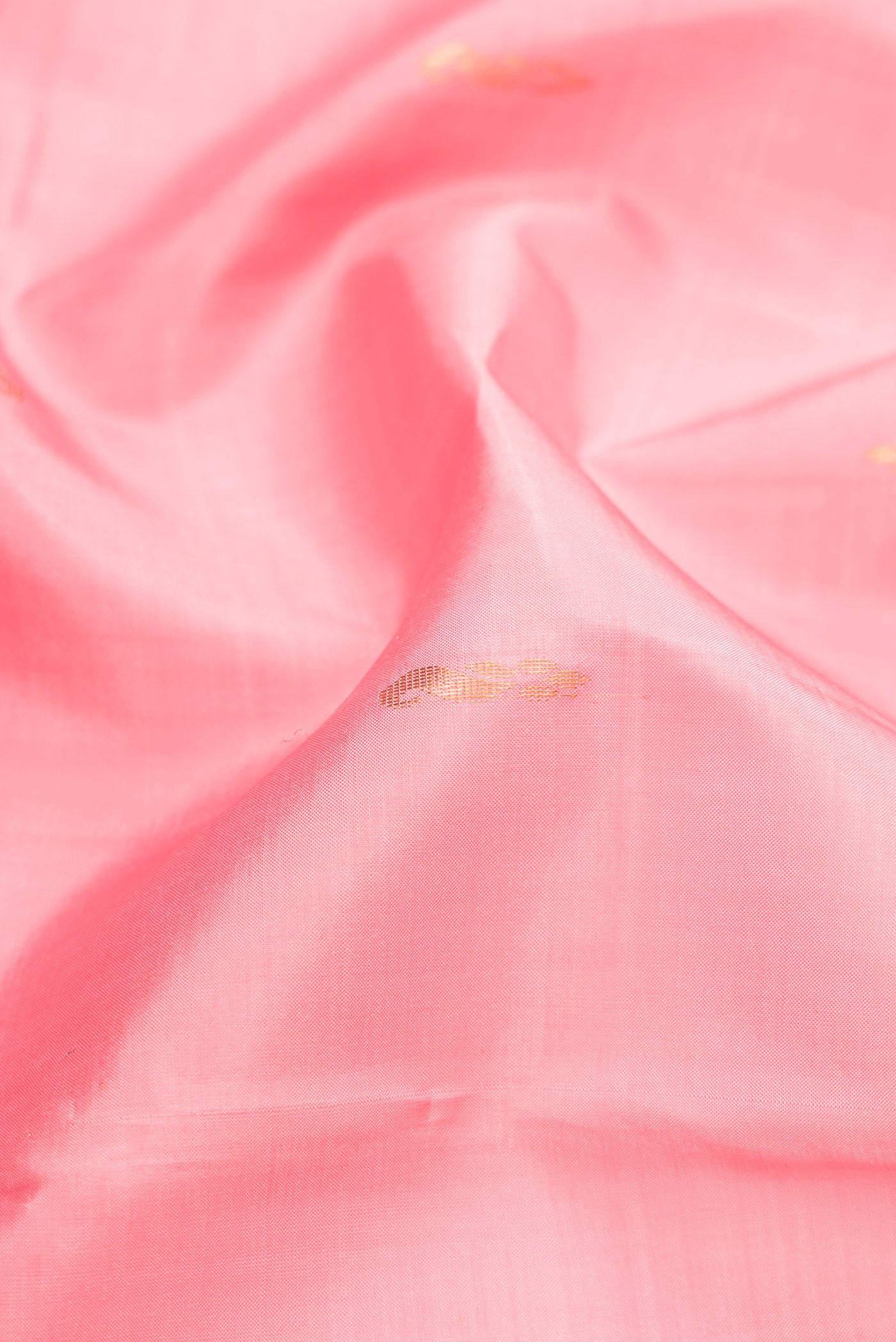 Close up of Rose pink Kanchipuram Silk Saree with Zari Butta on the body and Fancy Border.  displaying folds