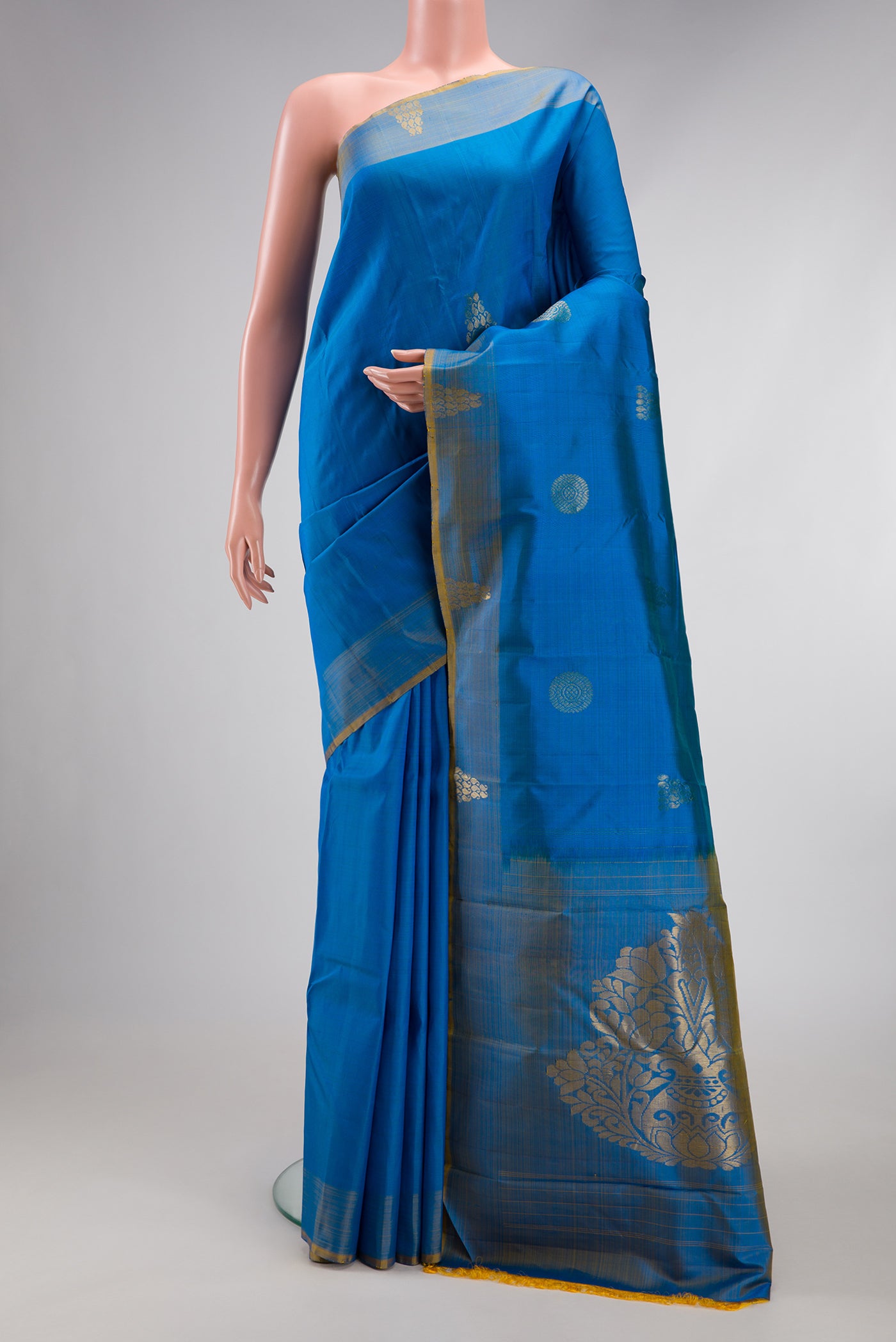Peacock Blue Kanchipuram Silk Saree with Zari Butta on the body and Zari Border.  displayed on a mannequin