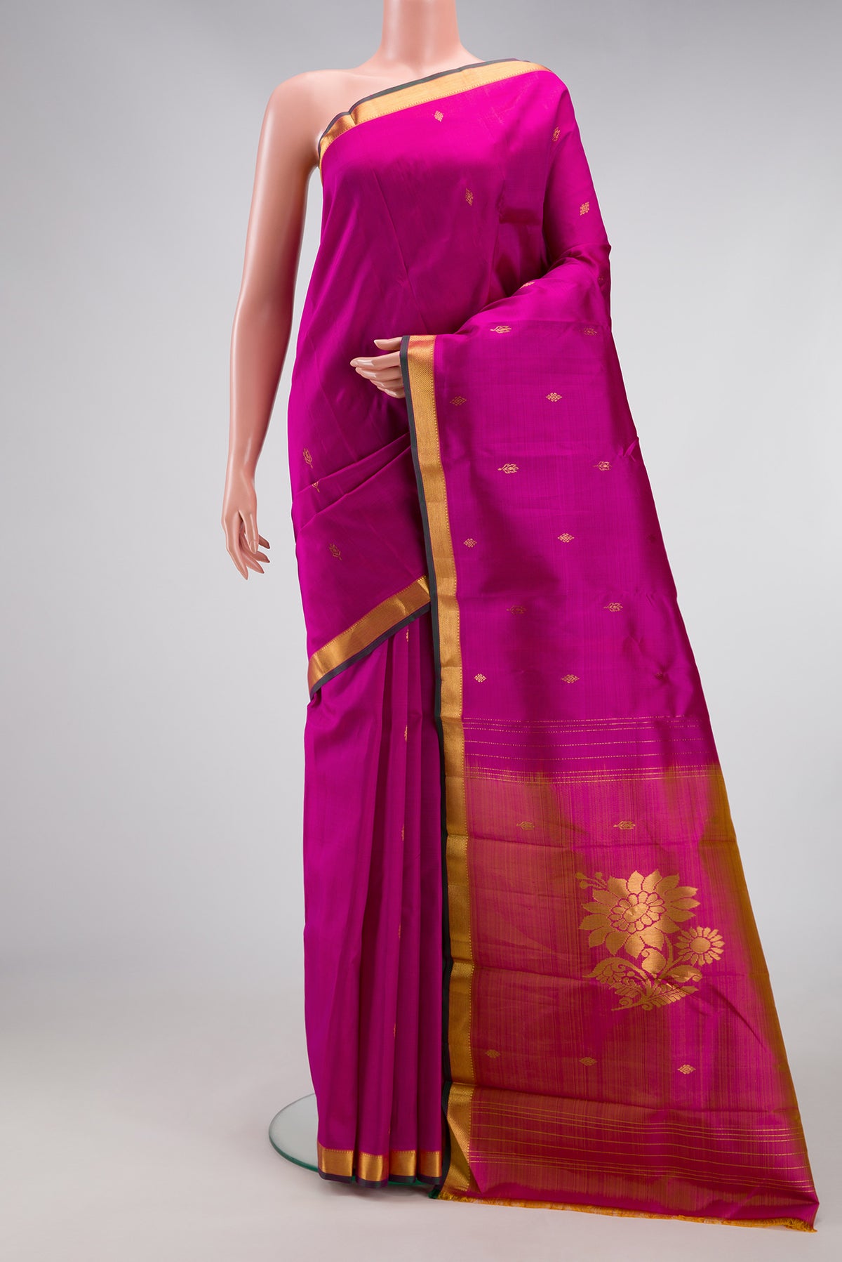 Magenta Kanchipuram Silk Saree with Zari Butta on the body and Zari Border.  displayed on a mannequin