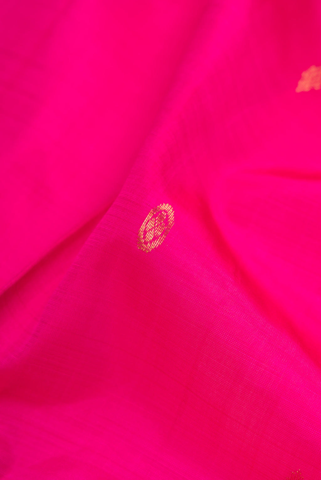 Close up of Pink Kanjivaram Silk Saree with Zari Butta on the body and Zari Border.  displaying folds