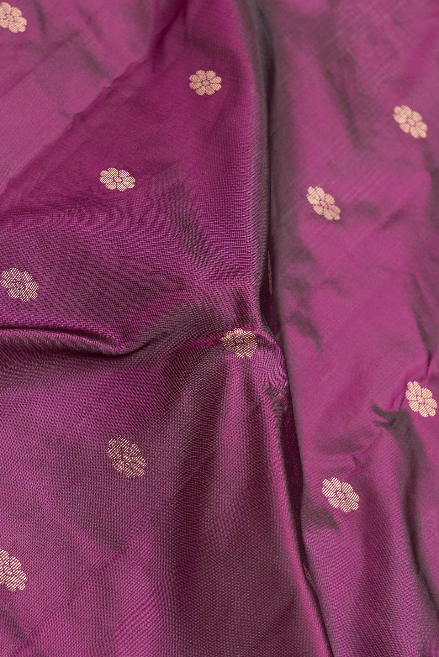 Close up of Magenta Dual Tone Blended Paithani Silk Saree with Zari Butta on the body and Zari Border.  displaying folds