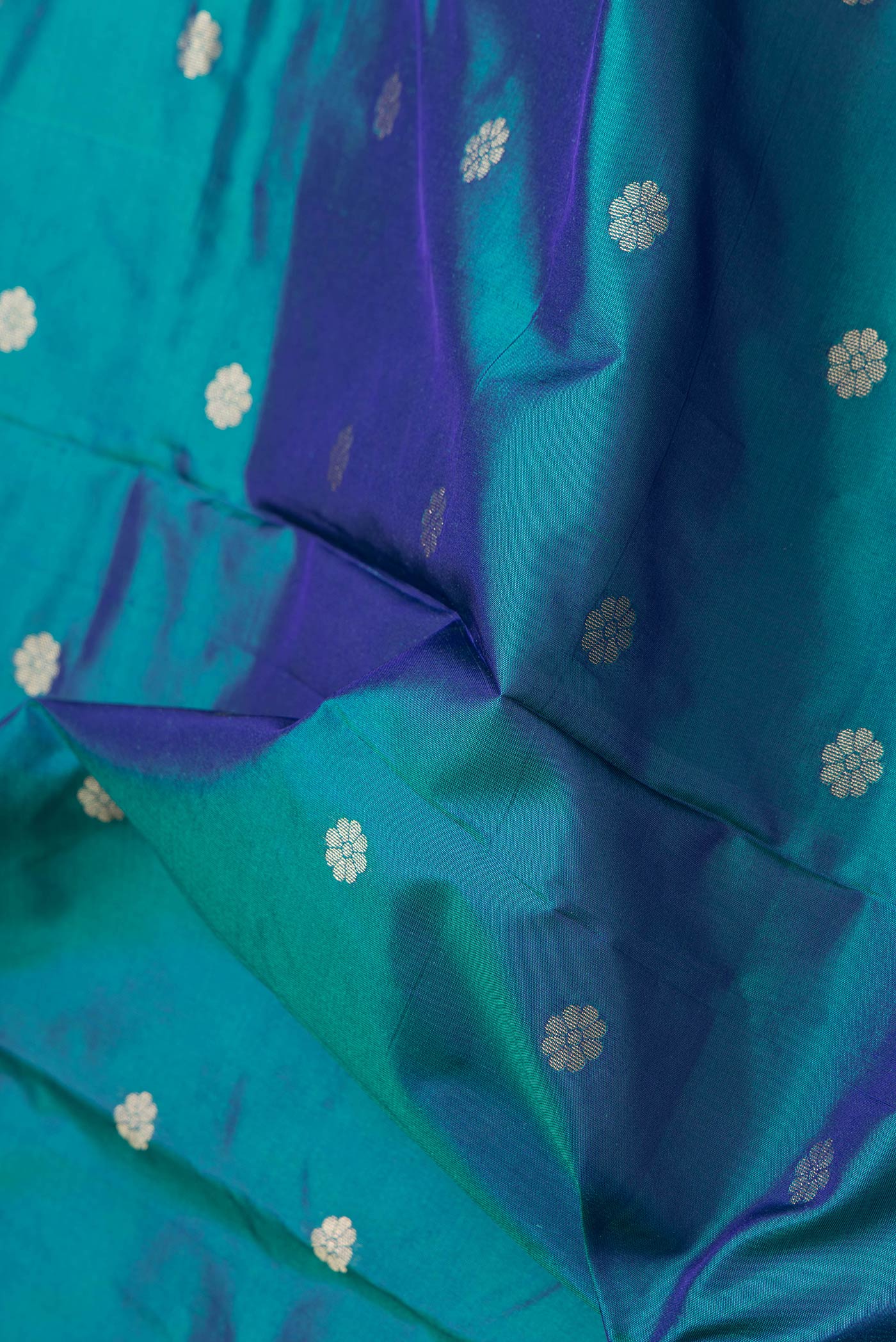 Close up of Peacock Blue Dual Tone Paithani Silk Saree with Zari Butta on the body and Zari Border.  displaying folds