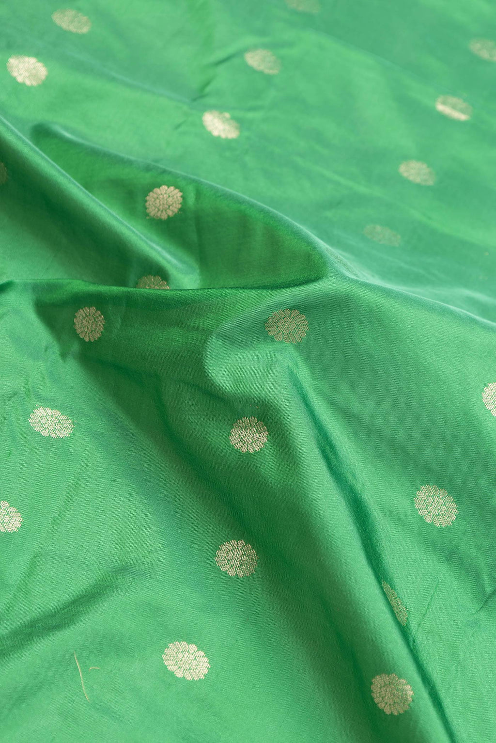 Close up of Green Dual Tone Blended Paithani Silk Saree with Zari Butta on the body and Zari Border.  displaying folds
