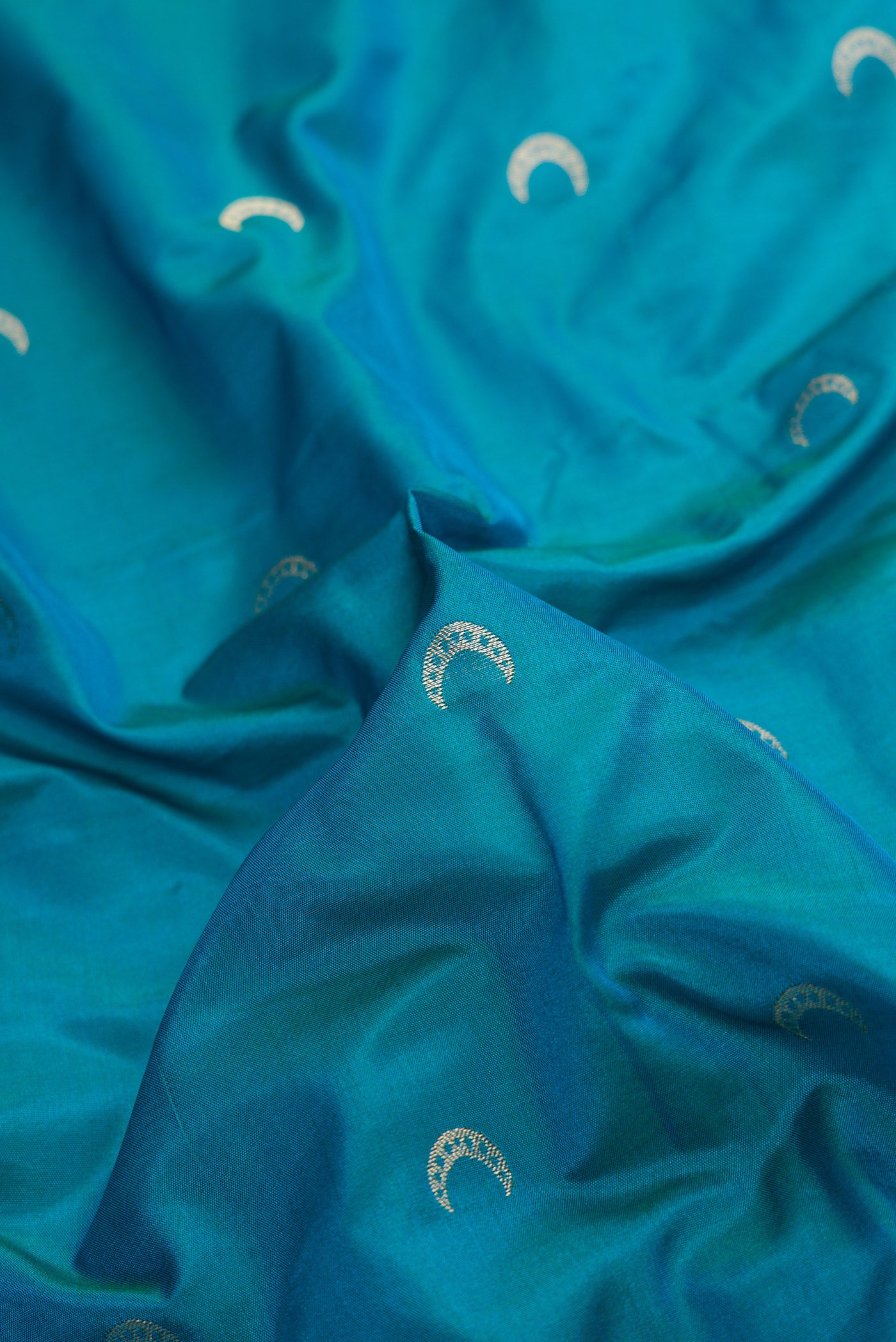 Close up of Sky Blue Dual Tone Blended Paithani Silk Saree with Zari Butta on the body and Zari Border.  displaying folds