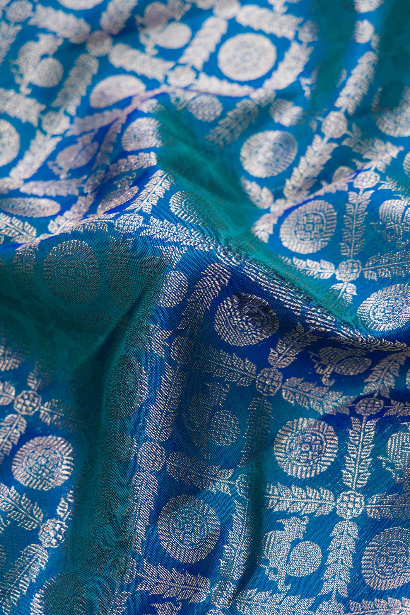 Close up of Peacock Blue Dual Tone Kanchipuram Silk Saree with Zari Brocade on the body and Zari Border.  displaying folds