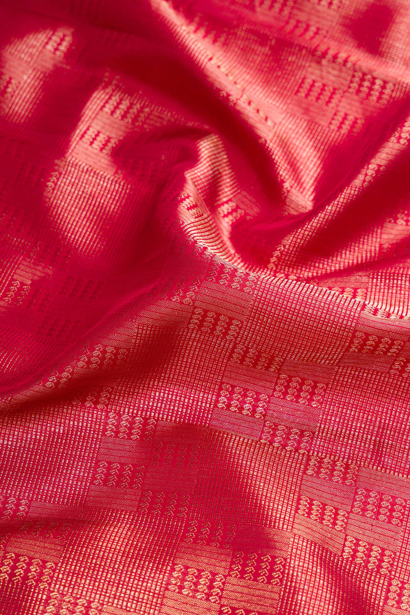 Close up of Dark Pink Dual Tone Kanchipuram Silk Saree with Zari Brocade on the body and Zari Border.  displaying folds