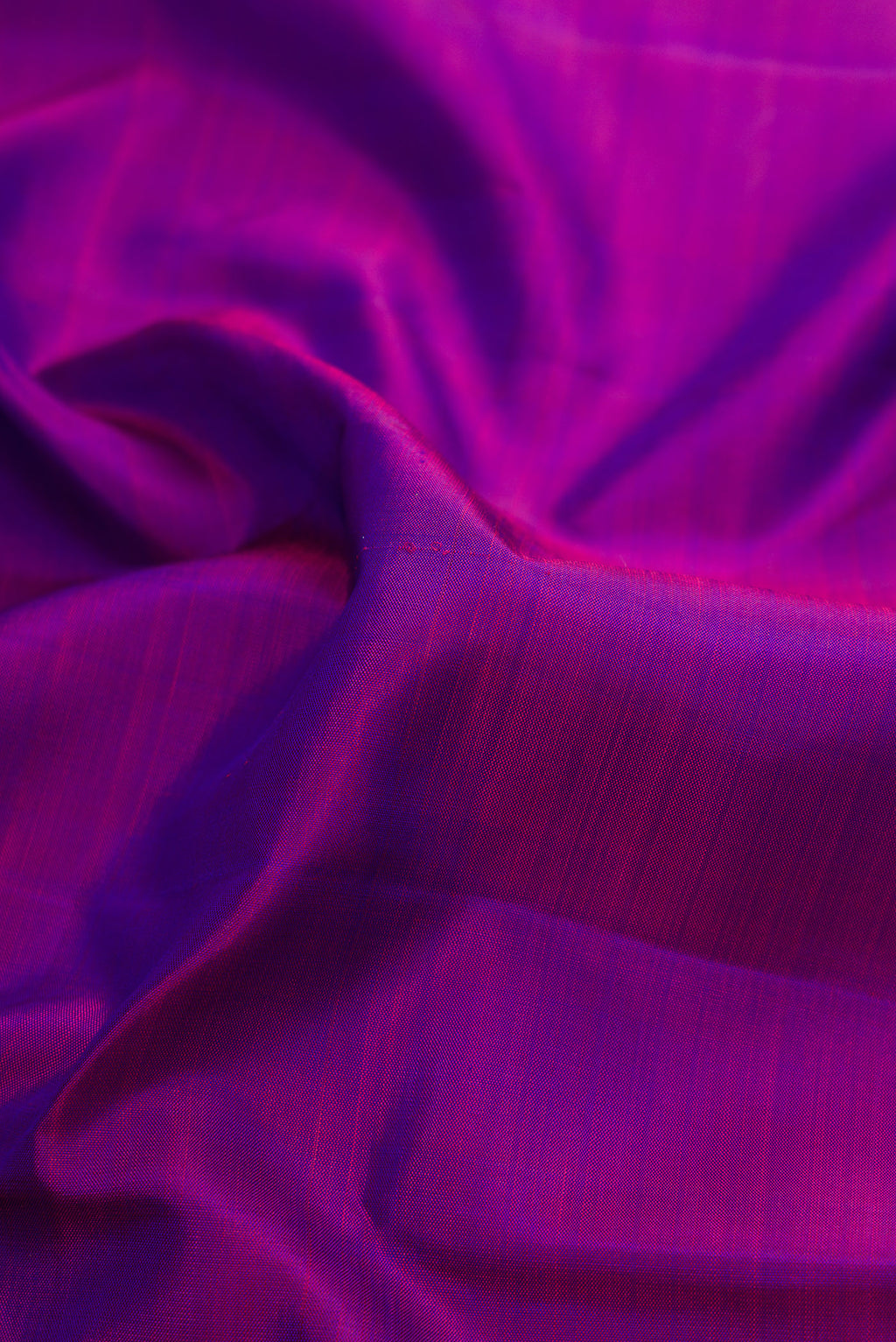 Close up of Purple Dual Tone Kanjivaram Silk Saree with Plain Body and Zari Border.  displaying folds