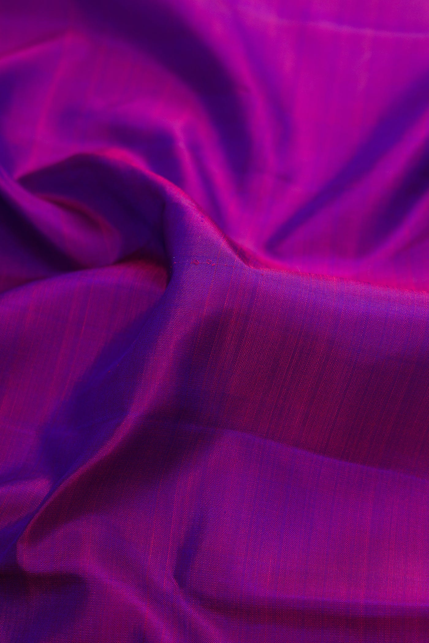 Close up of Purple Dual Tone Kanjivaram Silk Saree with Plain Body and Zari Border.  displaying folds