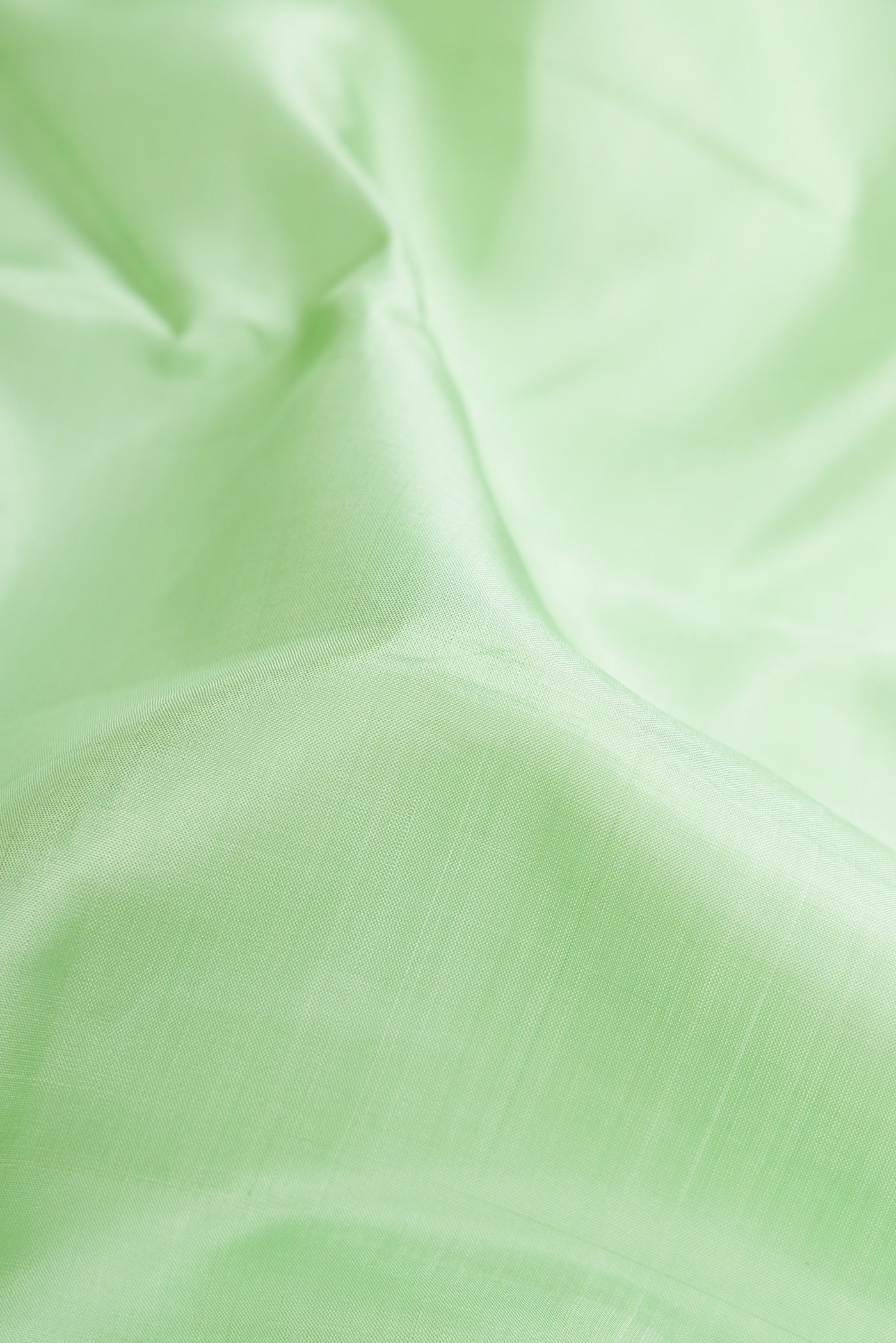 Close up of Pista Green Dual Tone Kanjivaram Silk Saree with Plain Body and Zari Border.  displaying folds