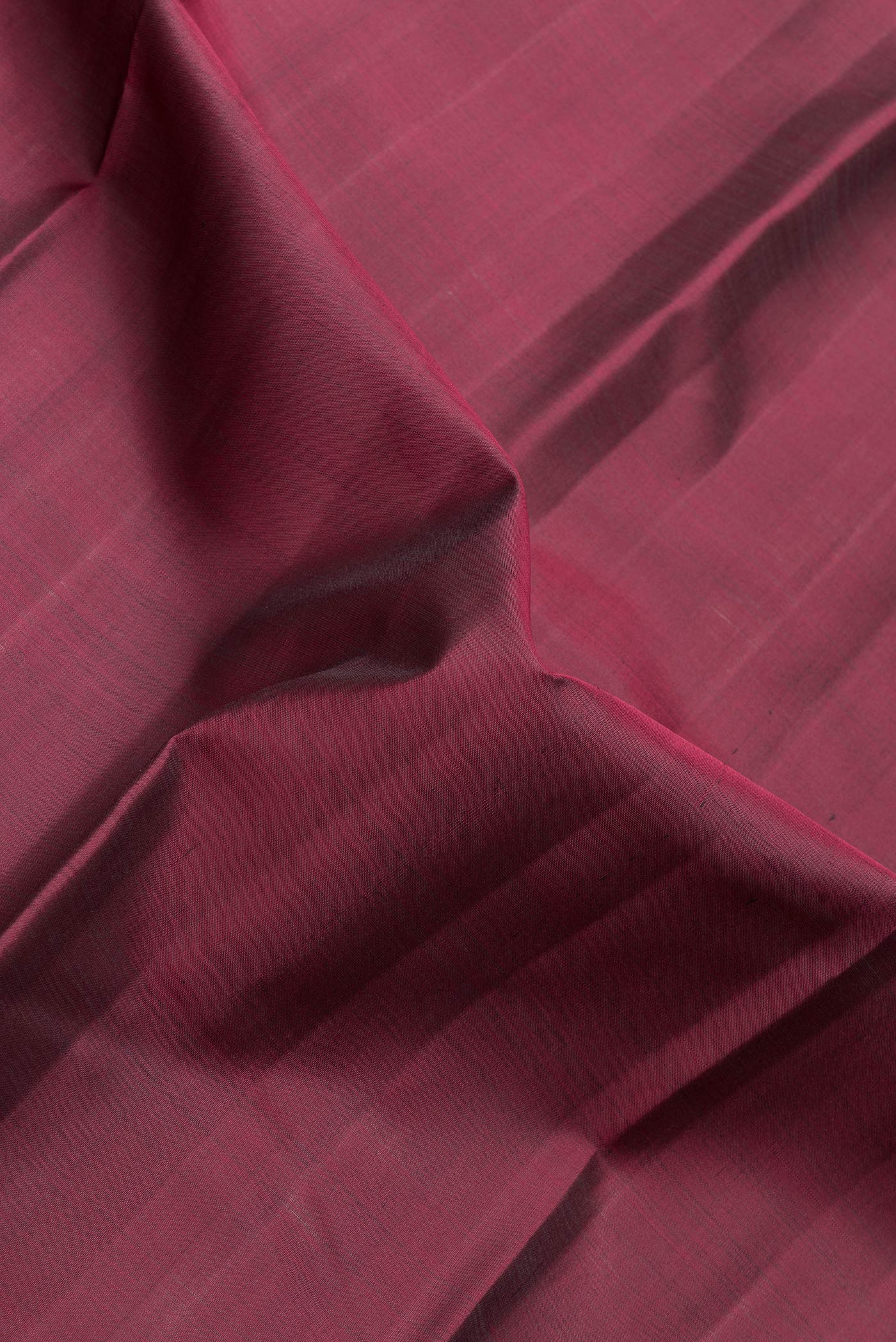 Close up of Maroon Dual Tone Kanjivaram Silk Saree with Plain Body and Zari Border.  displaying folds