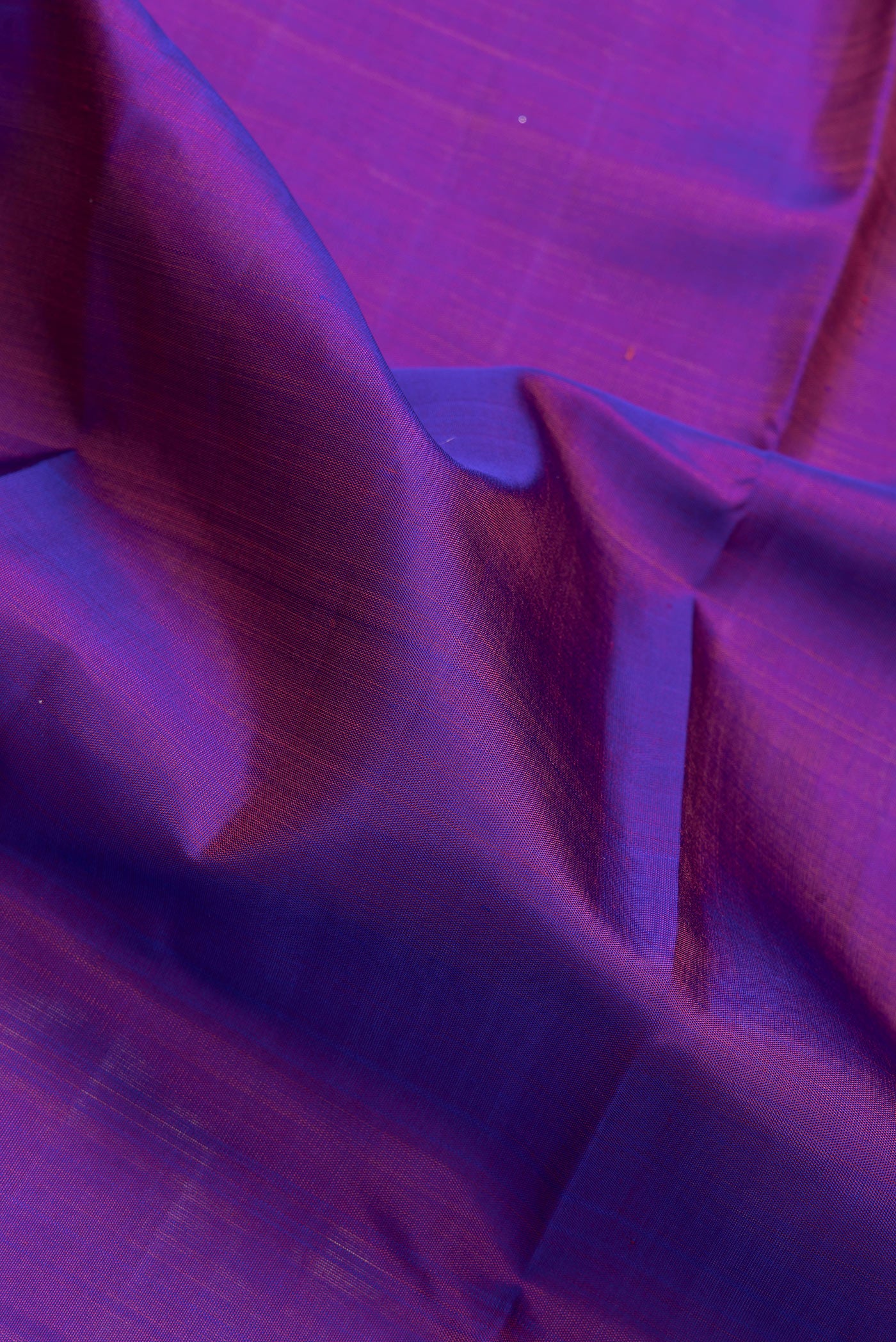 Close up of Purple Dual Tone Kanjivaram Silk Saree with Plain Body and Zari Border.  displaying folds