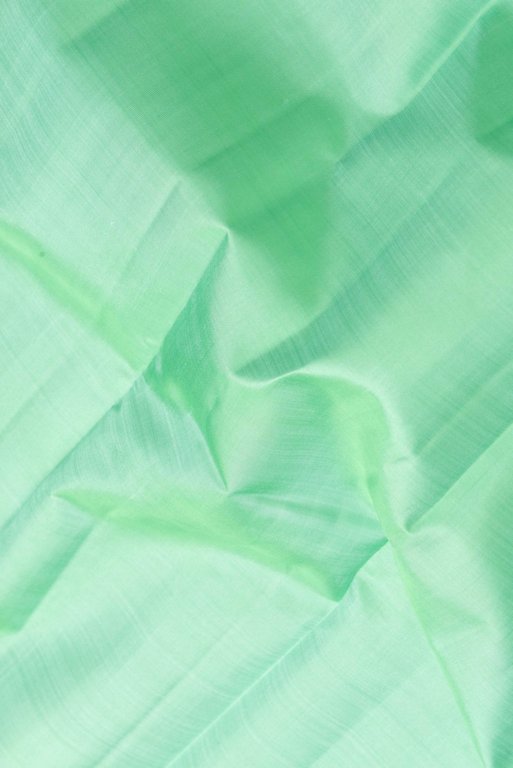 Close up of Sea Green Dual Tone Kanjivaram Silk Saree with Plain Body and Zari Border.  displaying folds