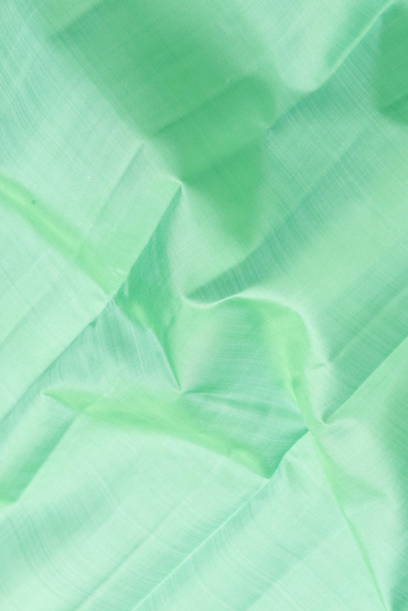 Close up of Sea Green Dual Tone Kanjivaram Silk Saree with Plain Body and Zari Border.  displaying folds