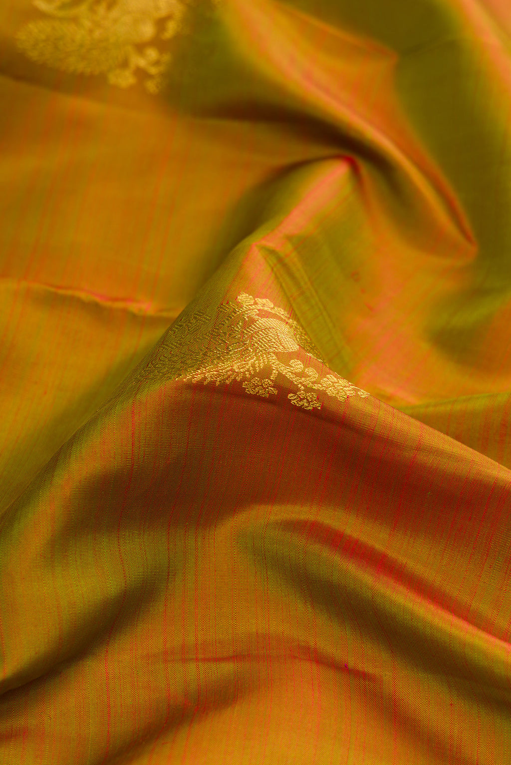 Close up of Mehandi Green Dual Tone Kanjivaram Silk Saree with Zari Butta on the body and Zari Border.  displaying folds